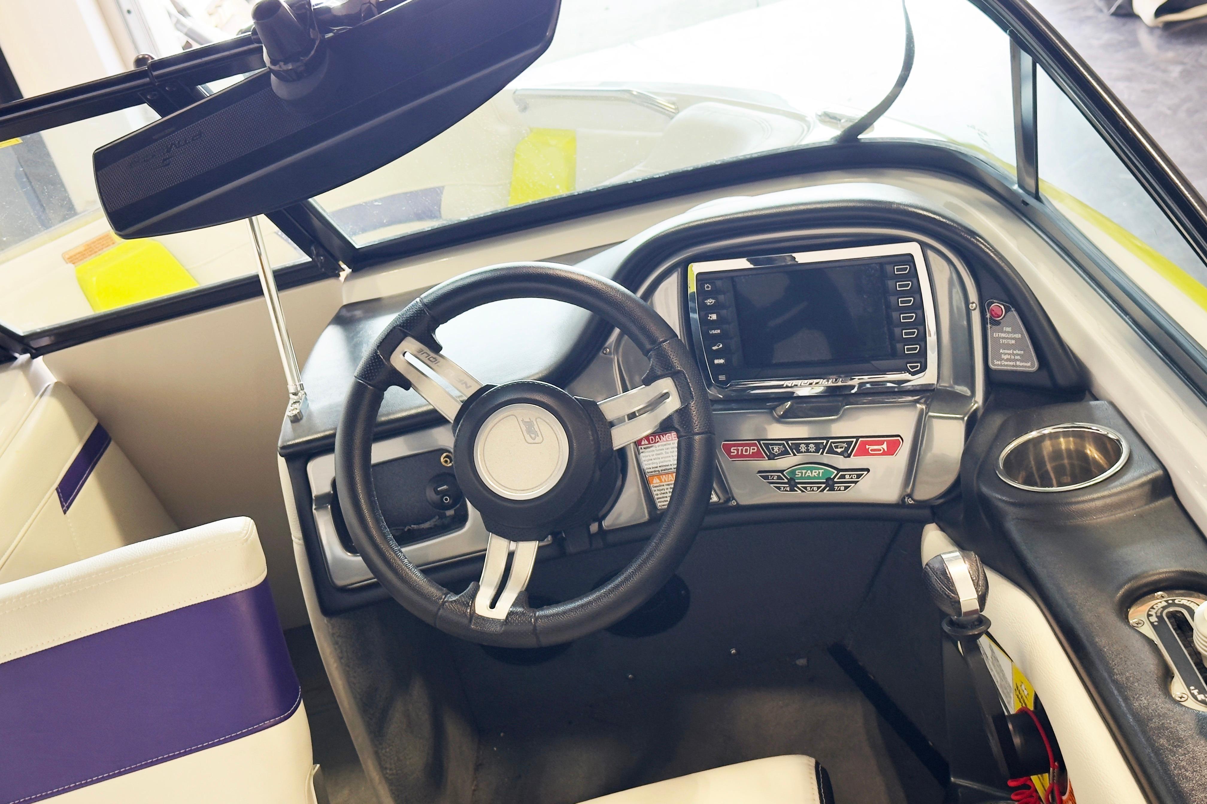 Interior of a 2014 Nautique Ski Nautique 200 boat, featuring steering wheel and control panel.