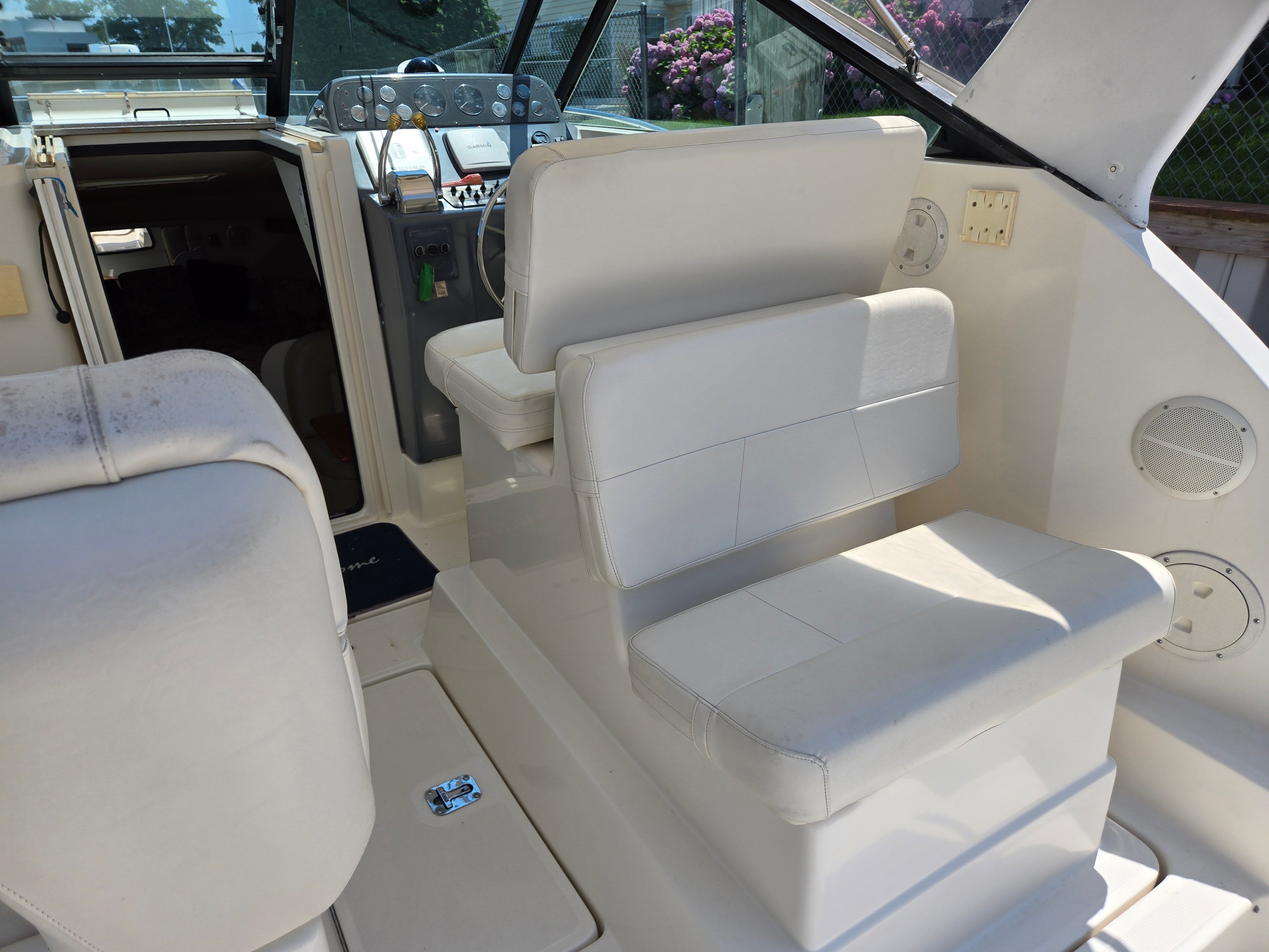 Interior of a 1997 Tiara Yachts Open with white seating and helm console.