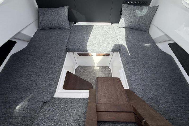 2025 Axopar 29 XC Cross Cabin interior with gray cushions and wooden accents.