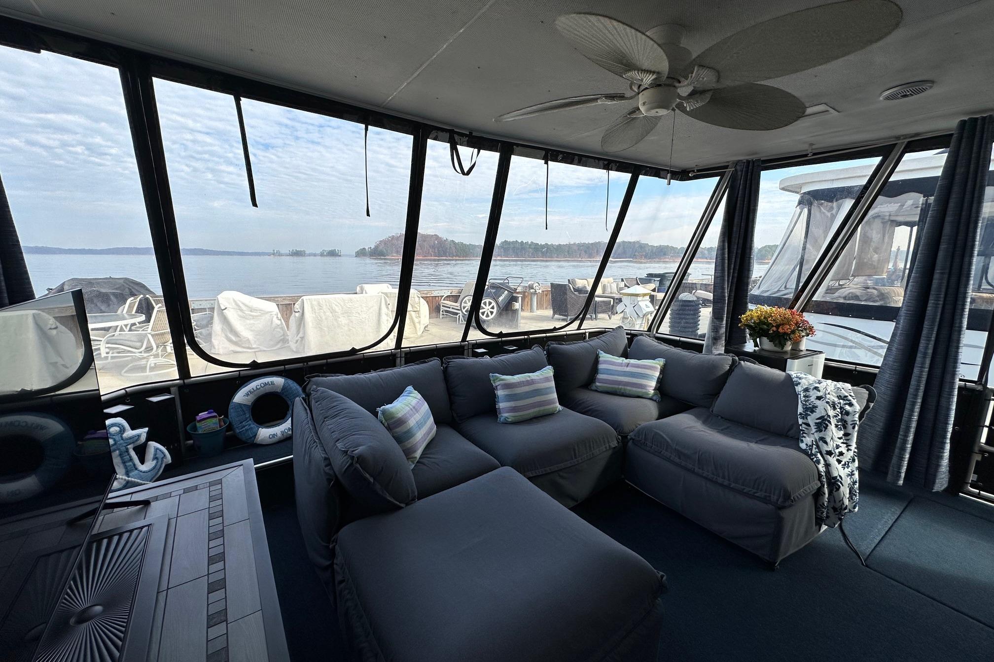 Interior of 1995 Stardust Cruisers 16x75 houseboat with cozy seating and lake view.