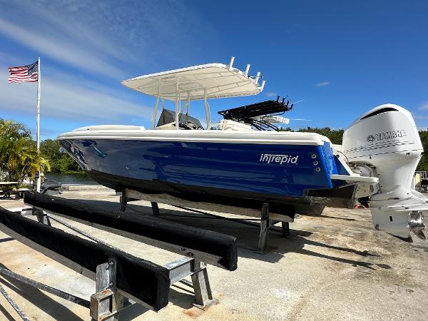 2005 Intrepid 323 boat on trailer with Yamaha engine, American flag in background.