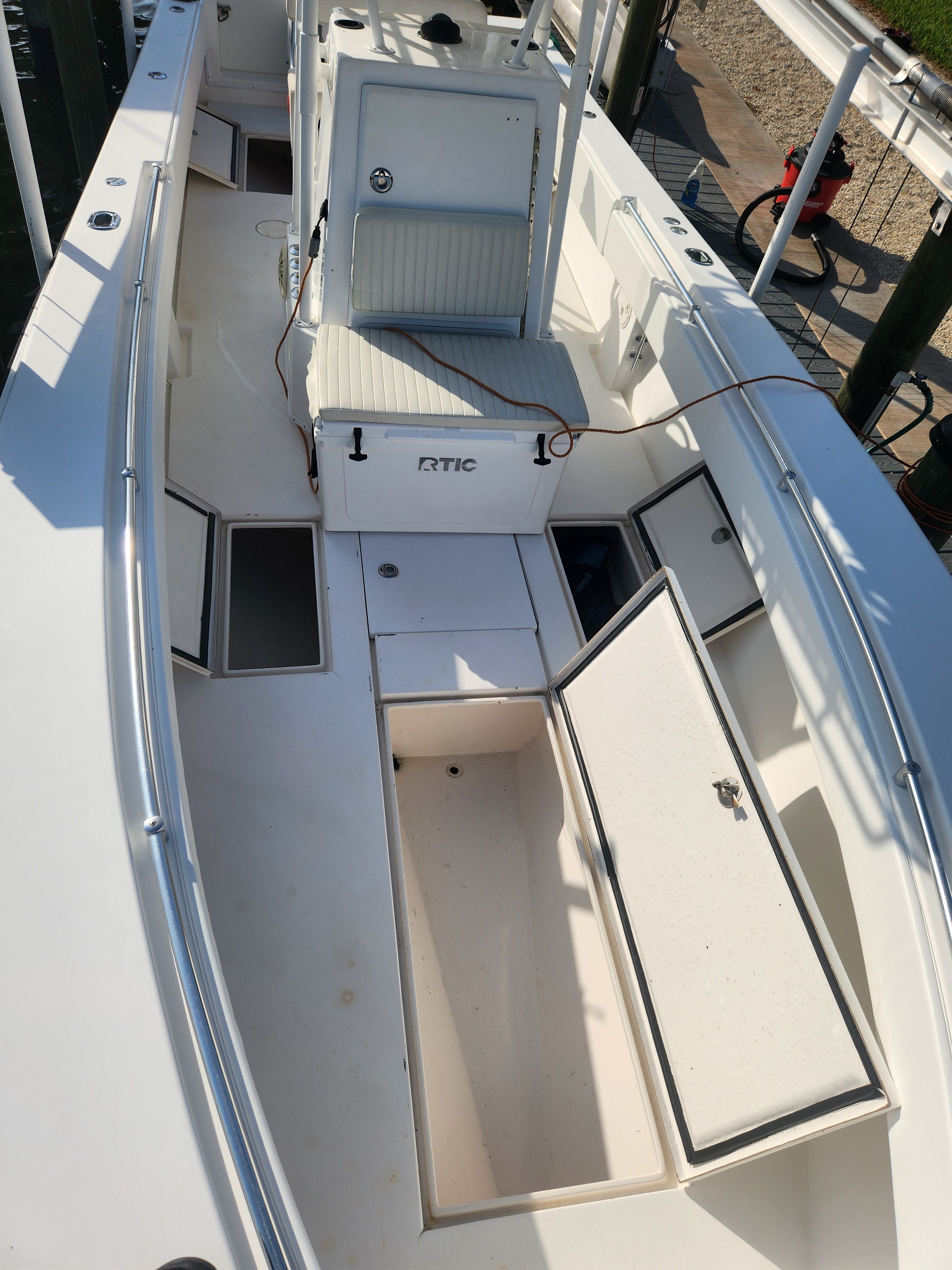 The image shows the deck of a 2005 Contender 27T boat with open storage compartments.