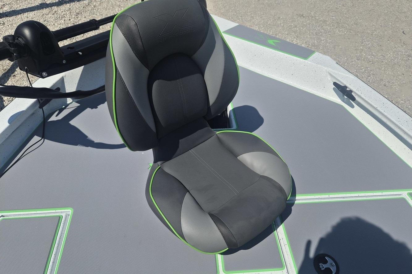 Comfortable seat on 2026 Xpress H18 boat deck, featuring sleek design and green accents.