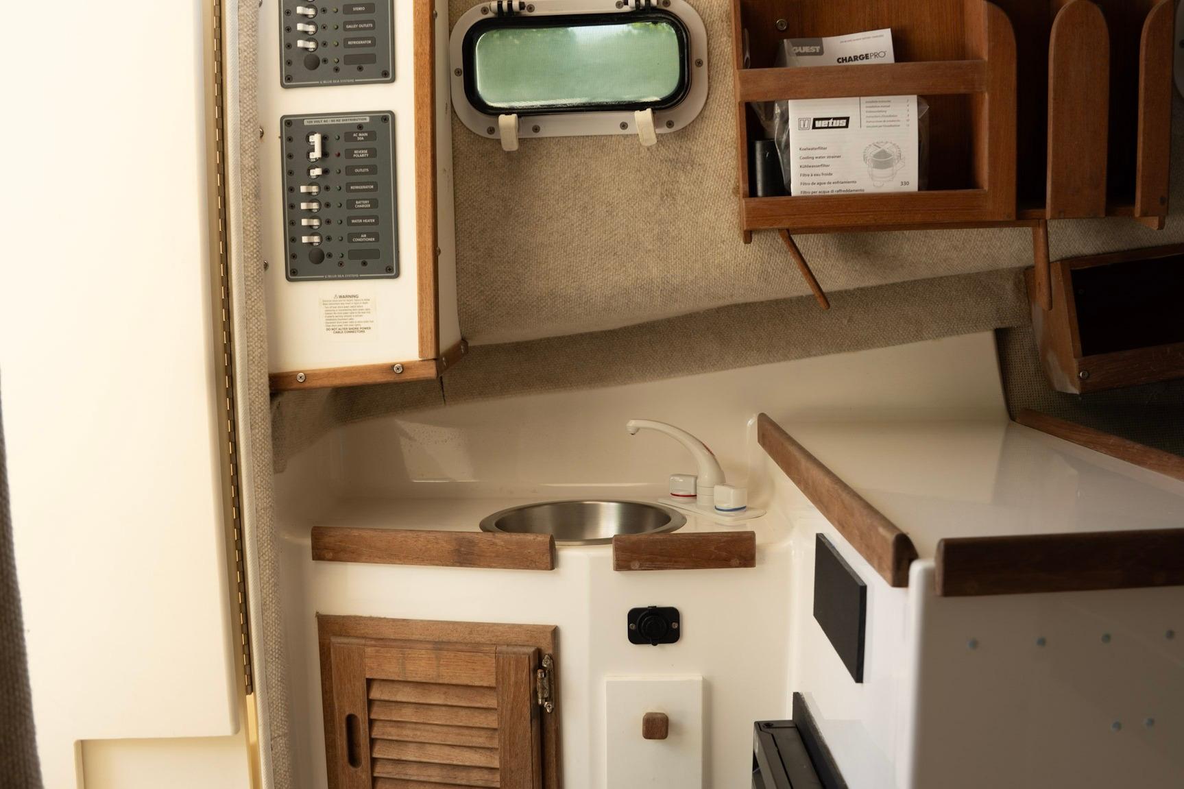 Interior of 2006 Atlas Boat Works Acadia 25, featuring a compact kitchenette and control panel.