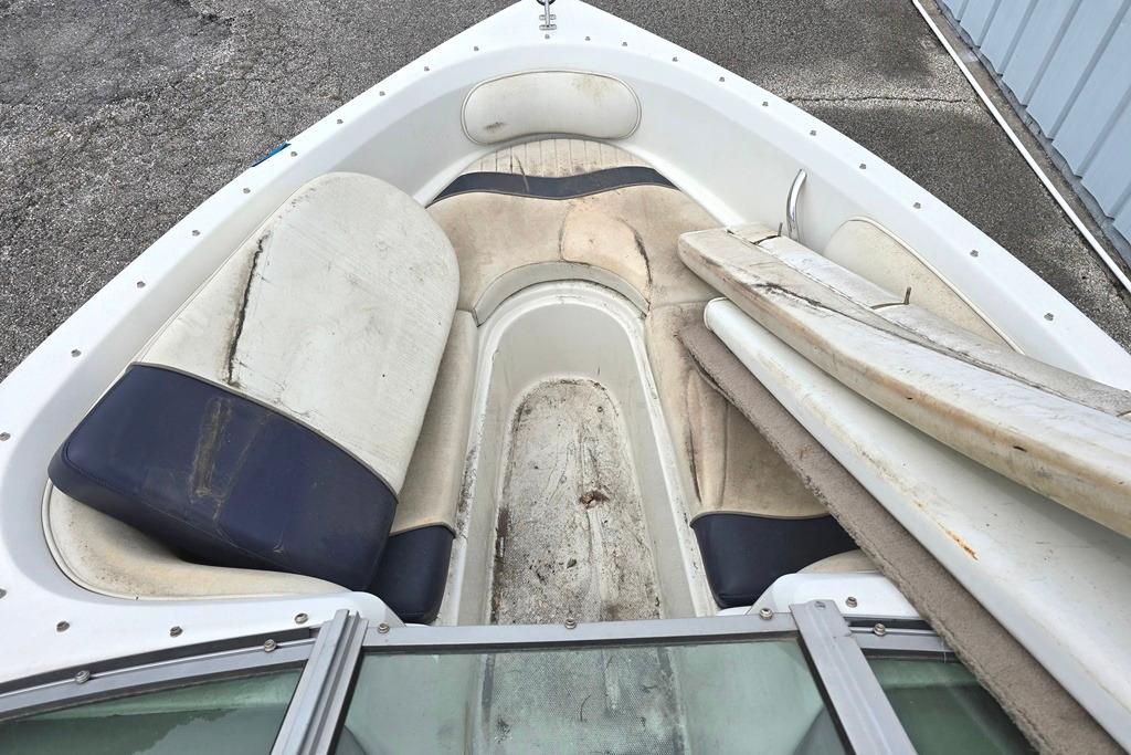2003 Caravelle 187 Bow Rider boat interior with worn seating and storage area.