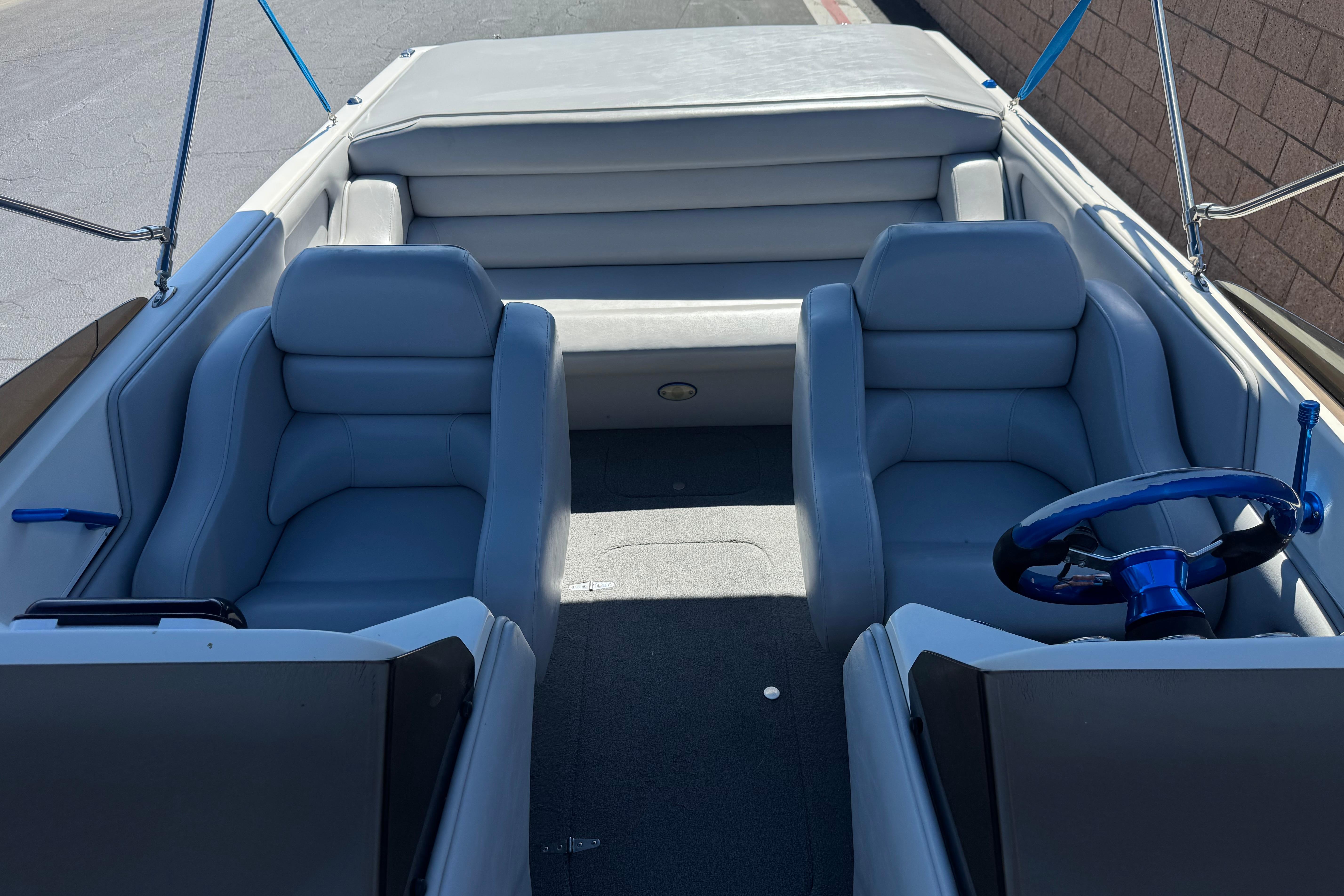 2007 Commander 2300LX boat interior with gray seating and blue steering wheel.