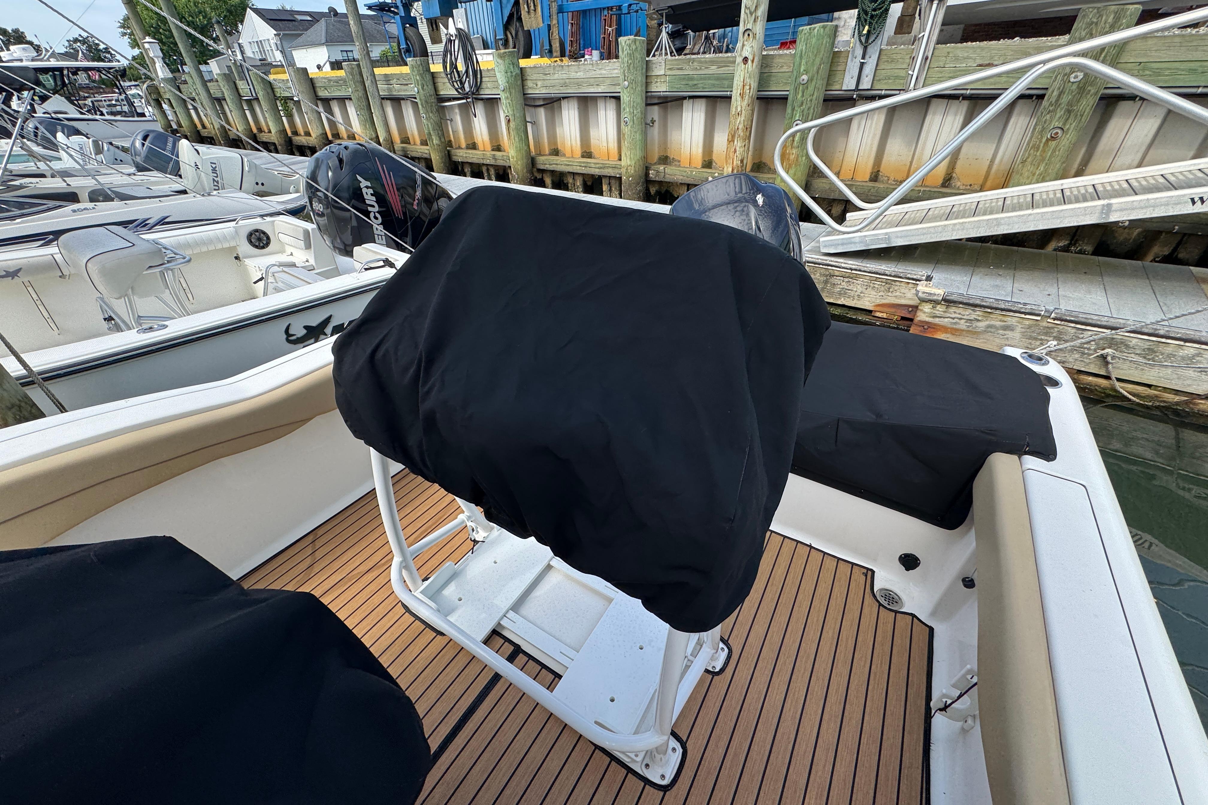 2016 Tidewater 230 LXF boat with covered seats and Mercury engines docked.