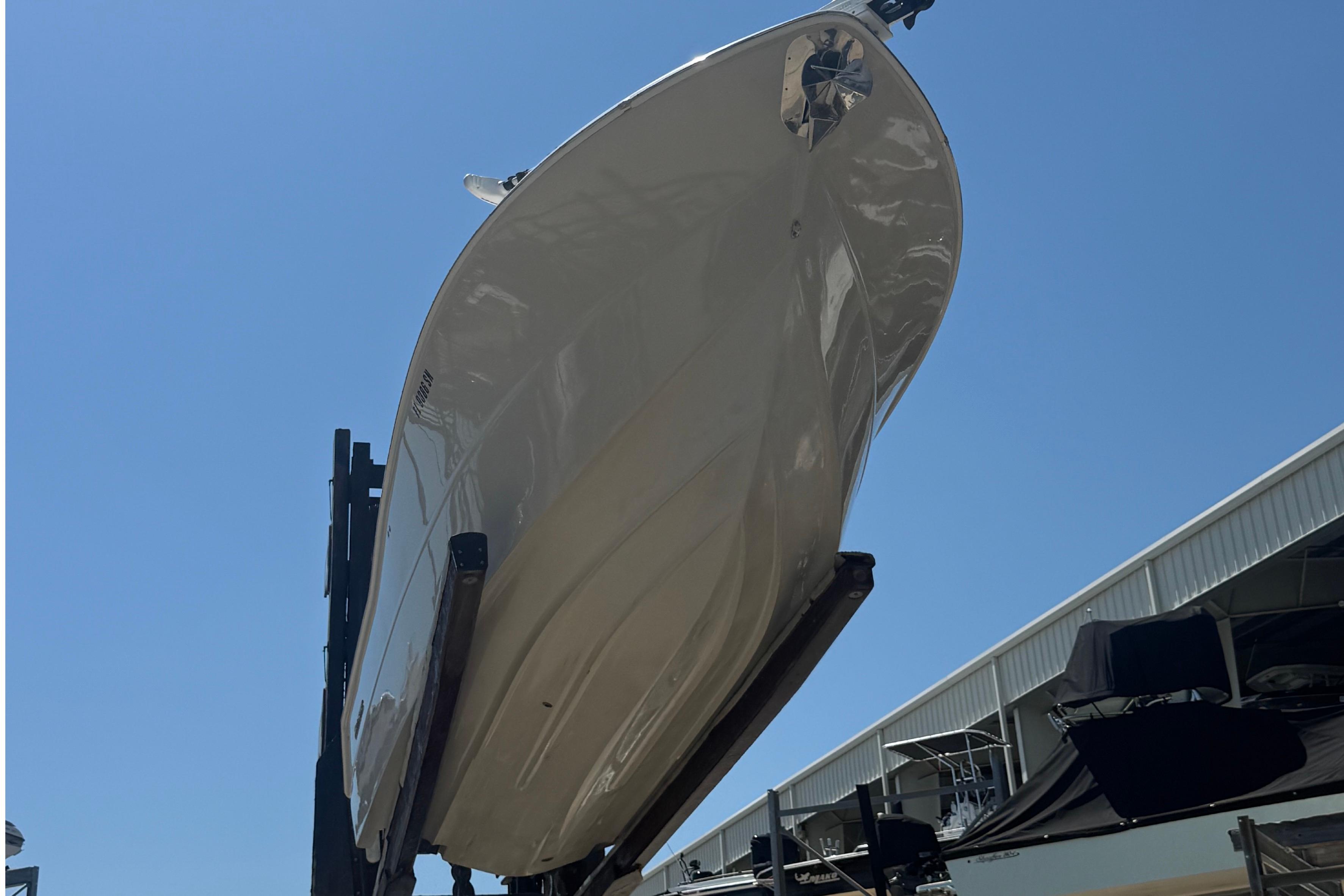 2019 Key West Billistic 281 Center Console boat on lift under clear blue sky.