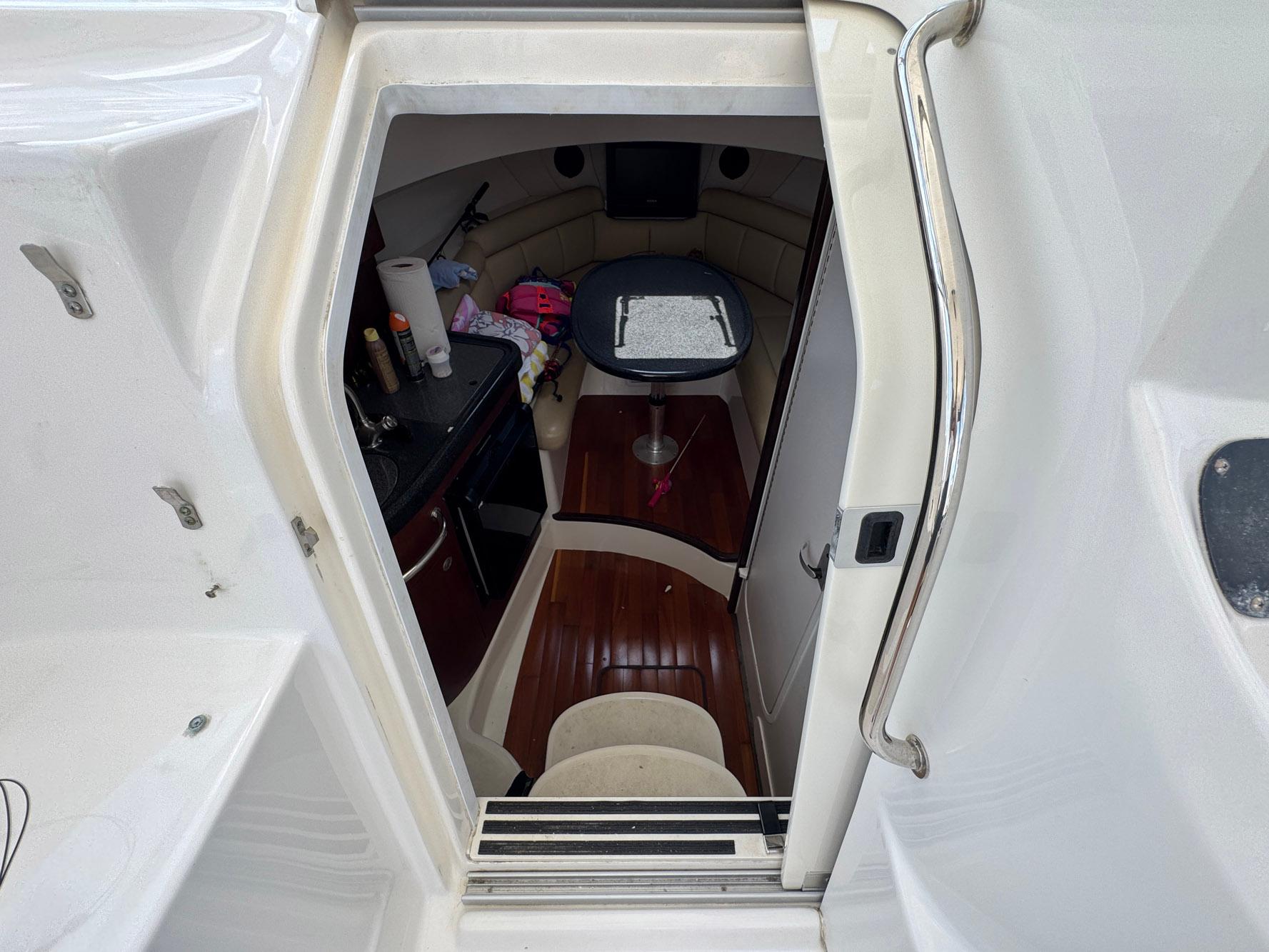 2011 Boston Whaler 305 Conquest cabin interior with table and seating area.
