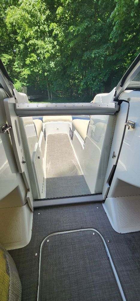 Interior view of a Sea-Doo sport boat with gray carpet and white walls.