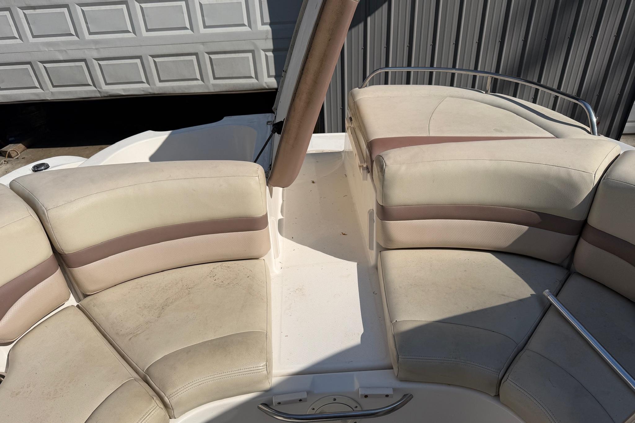 2005 Chaparral 256 SSi boat interior with beige seating and metal railing.