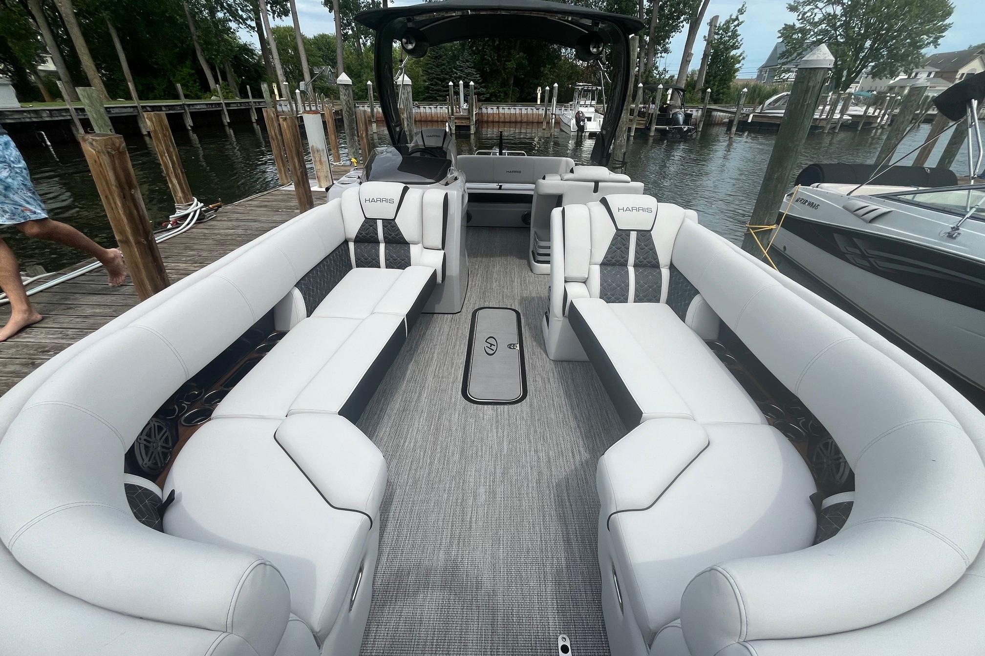2024 Harris Grand Mariner 250 pontoon boat with luxurious seating at a dock.