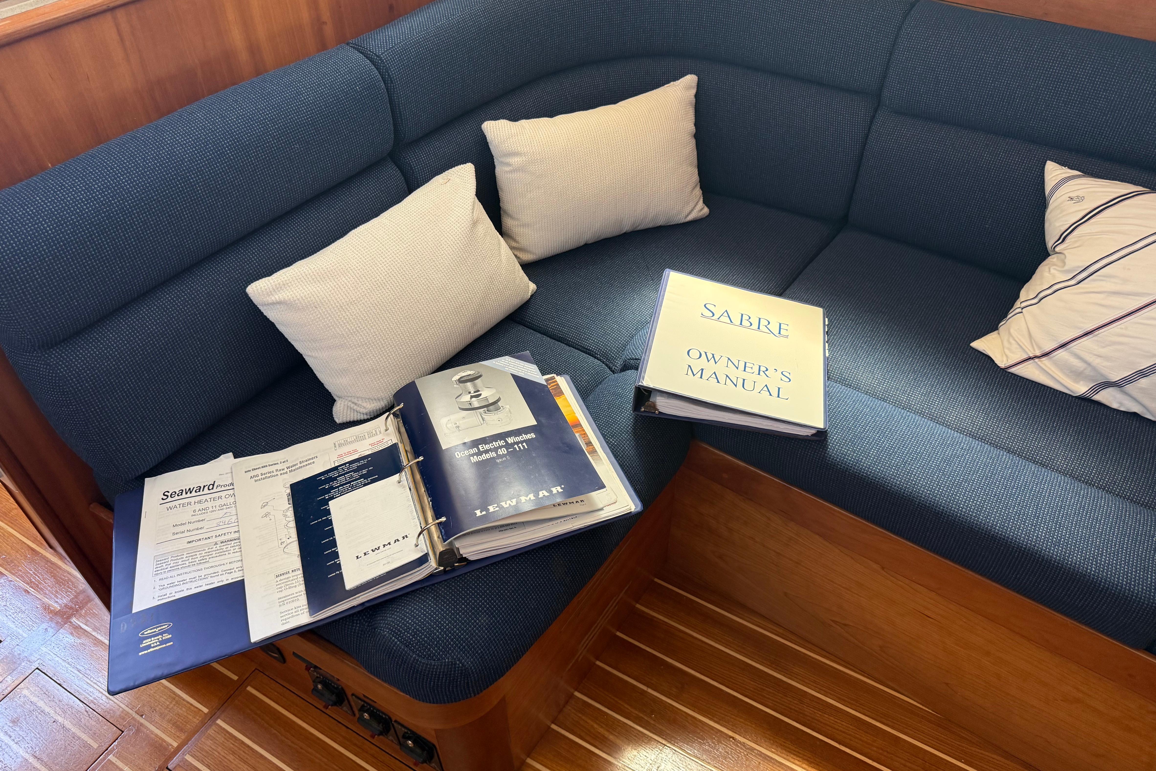 Cozy boat interior with manuals on a blue cushioned seat, Sabre 386, 2004 model.