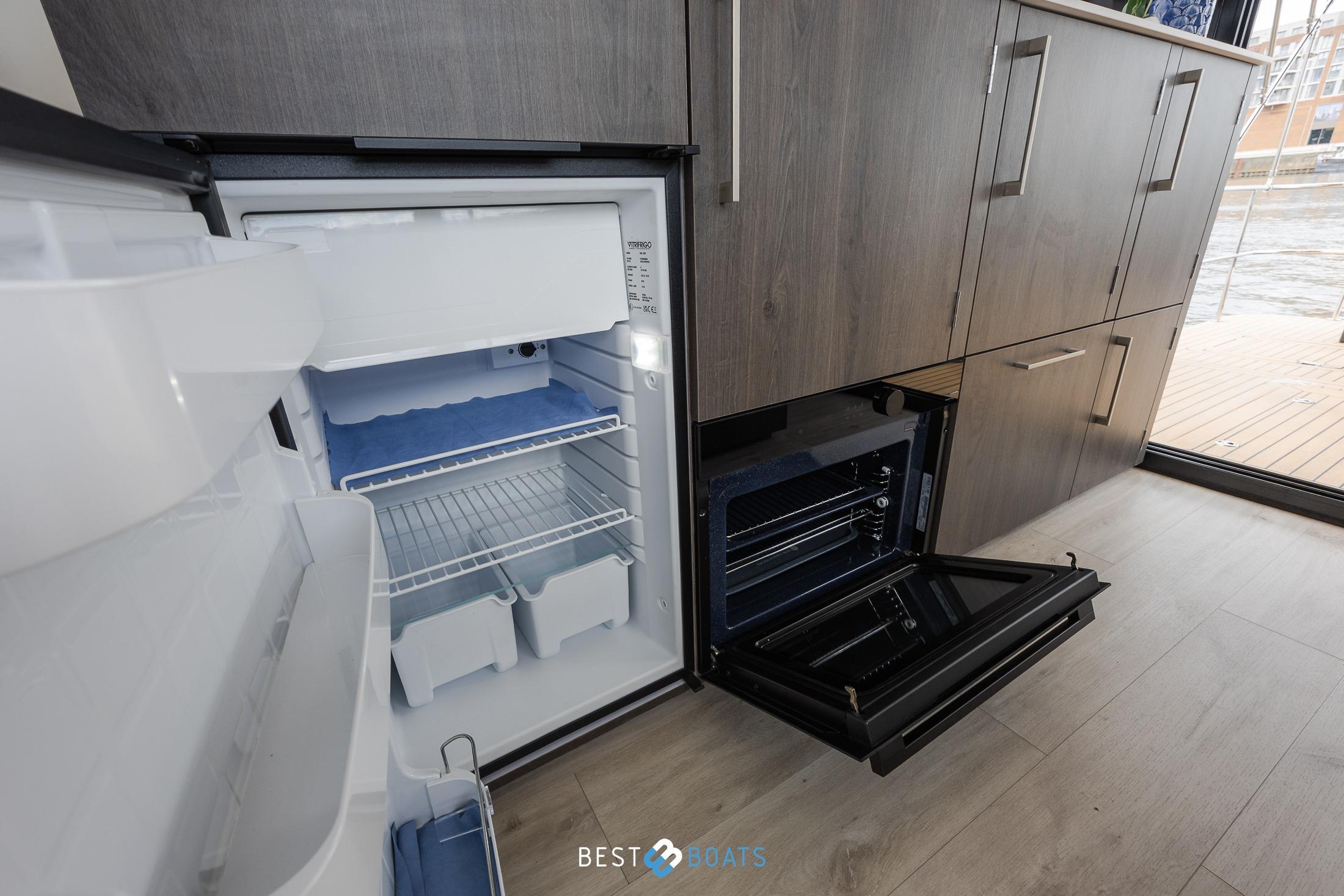 Modern kitchen interior of 2023 Cobra Yachts Futura 36 Premium Fly, featuring fridge and oven.
