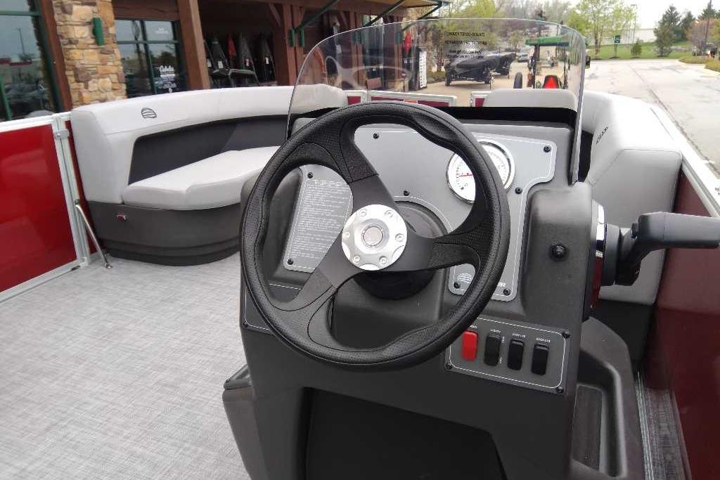 2026 Sun Tracker Party Barge 16 DLX interior with steering wheel and seating area.
