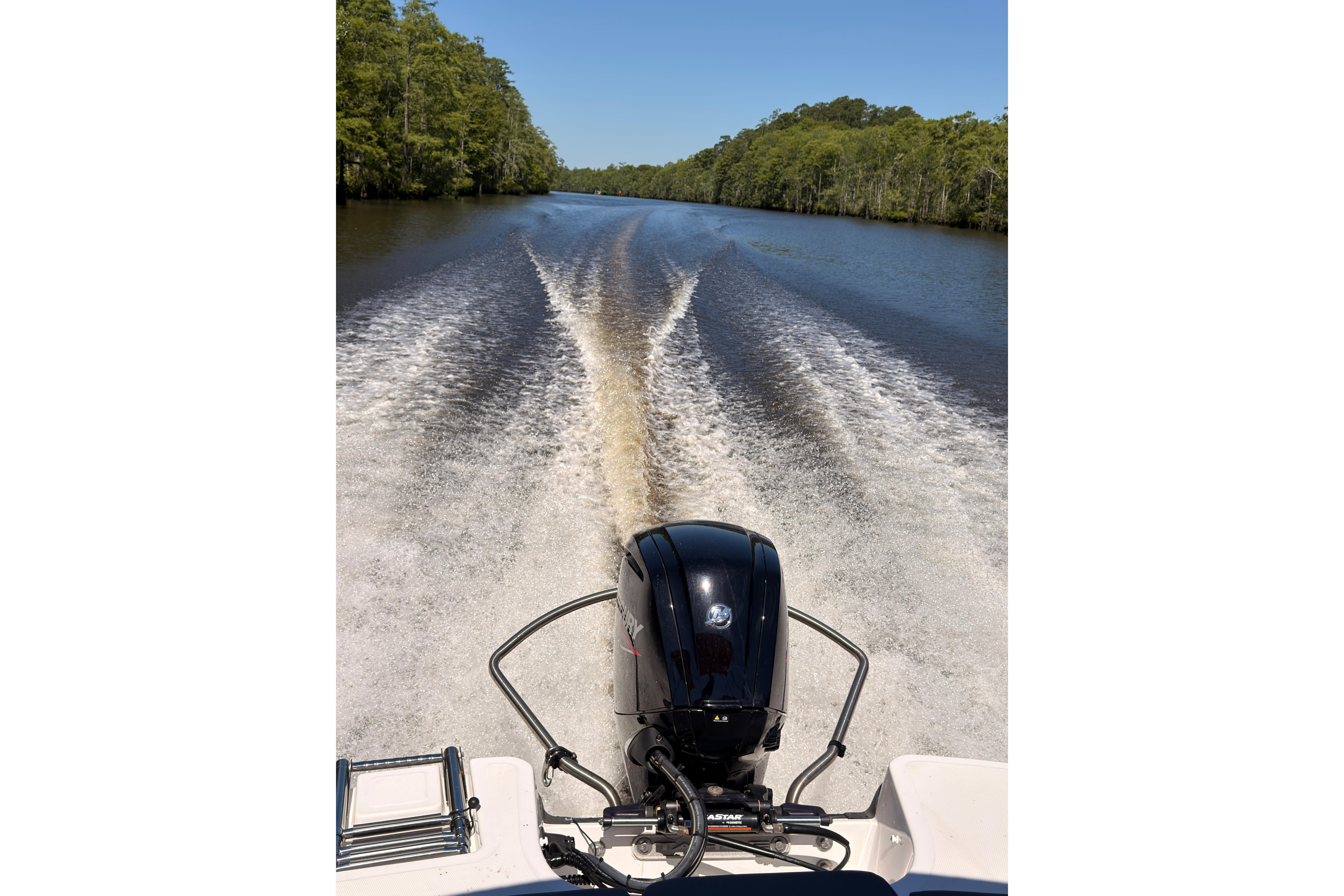 2022 Tahoe T18 boat cruising on a river, leaving a wake behind.