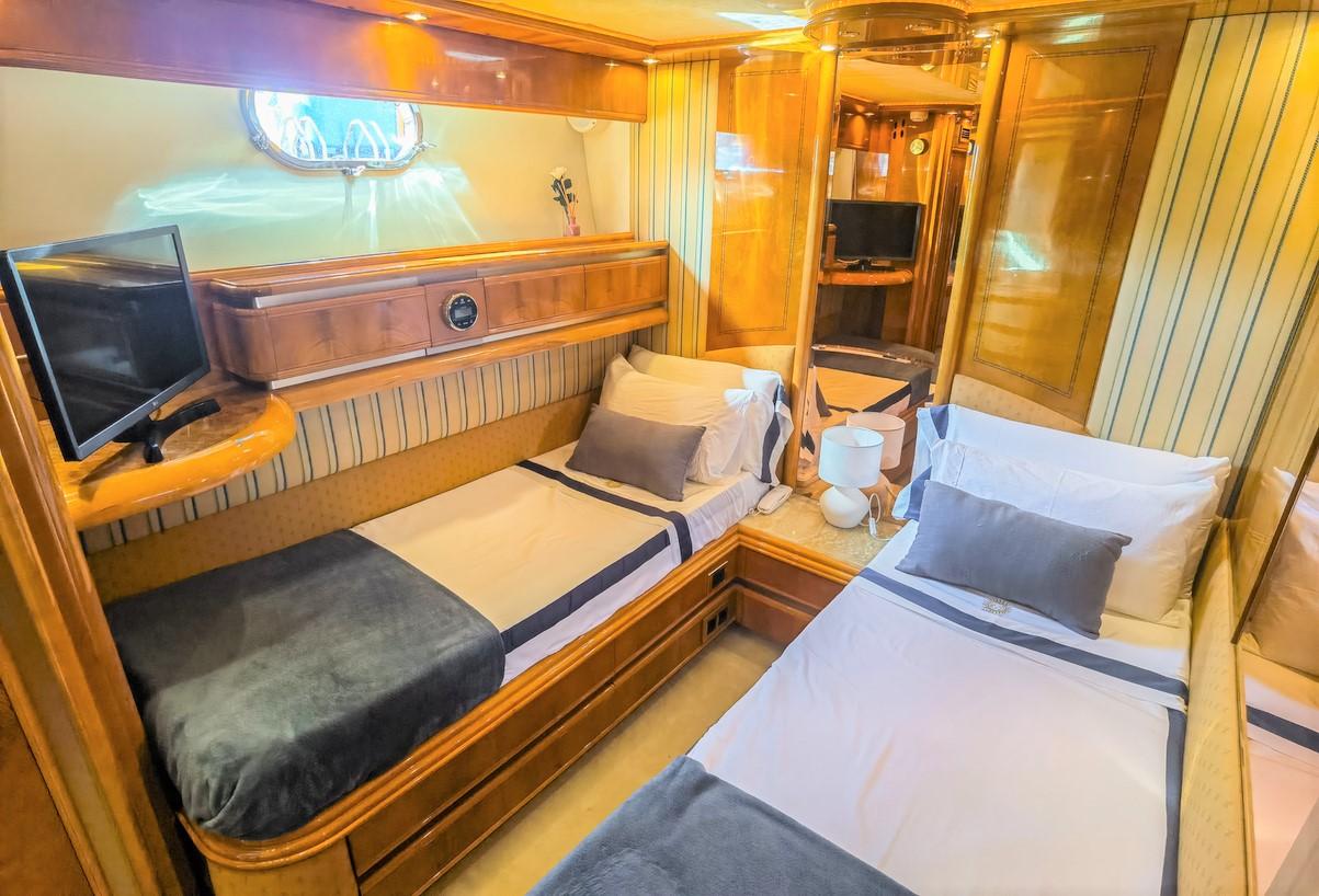 Luxurious twin cabin in 1997 Astondoa 95 GLX yacht with elegant wood finishes.