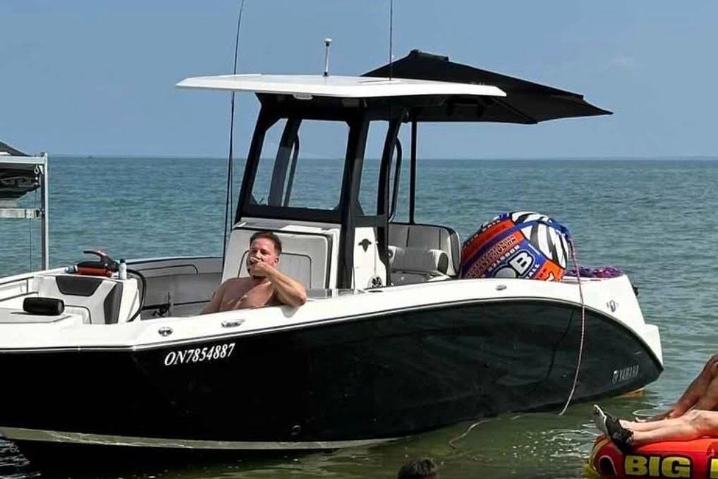 2022 Yamaha 255 FSH boat on water with people relaxing onboard.