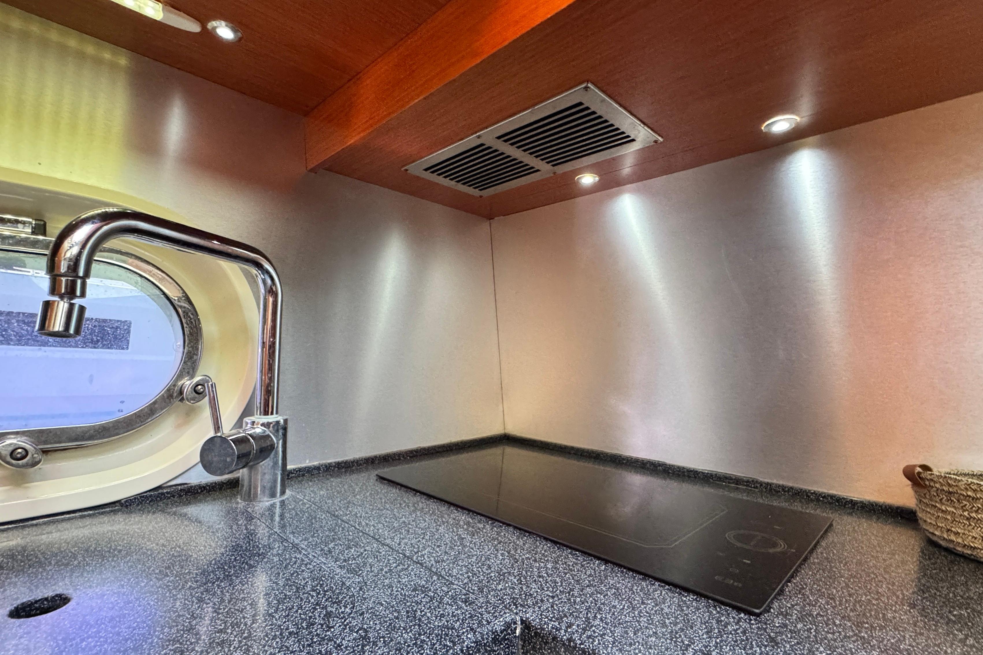 Modern kitchen in 2007 Doma 5 with sleek faucet and induction cooktop.