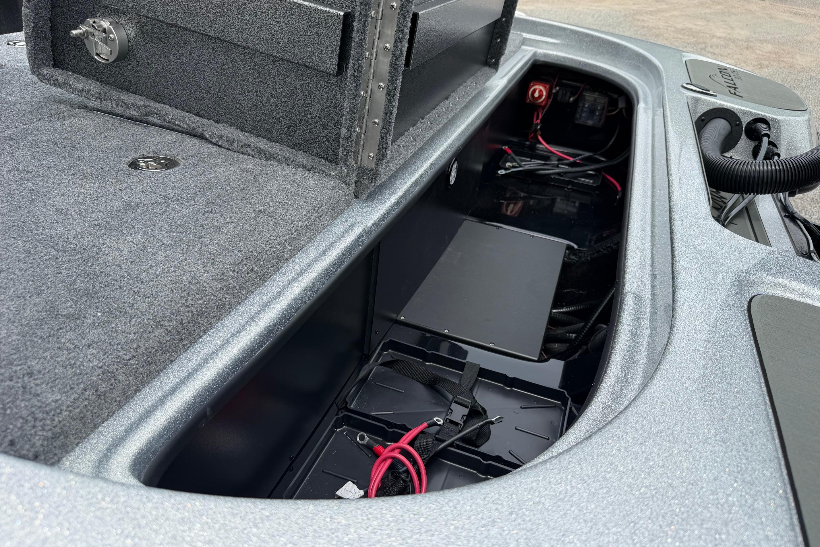 Open storage compartment of 2027 Falcon F20 PREDATOR boat, showcasing internal wiring and battery setup.