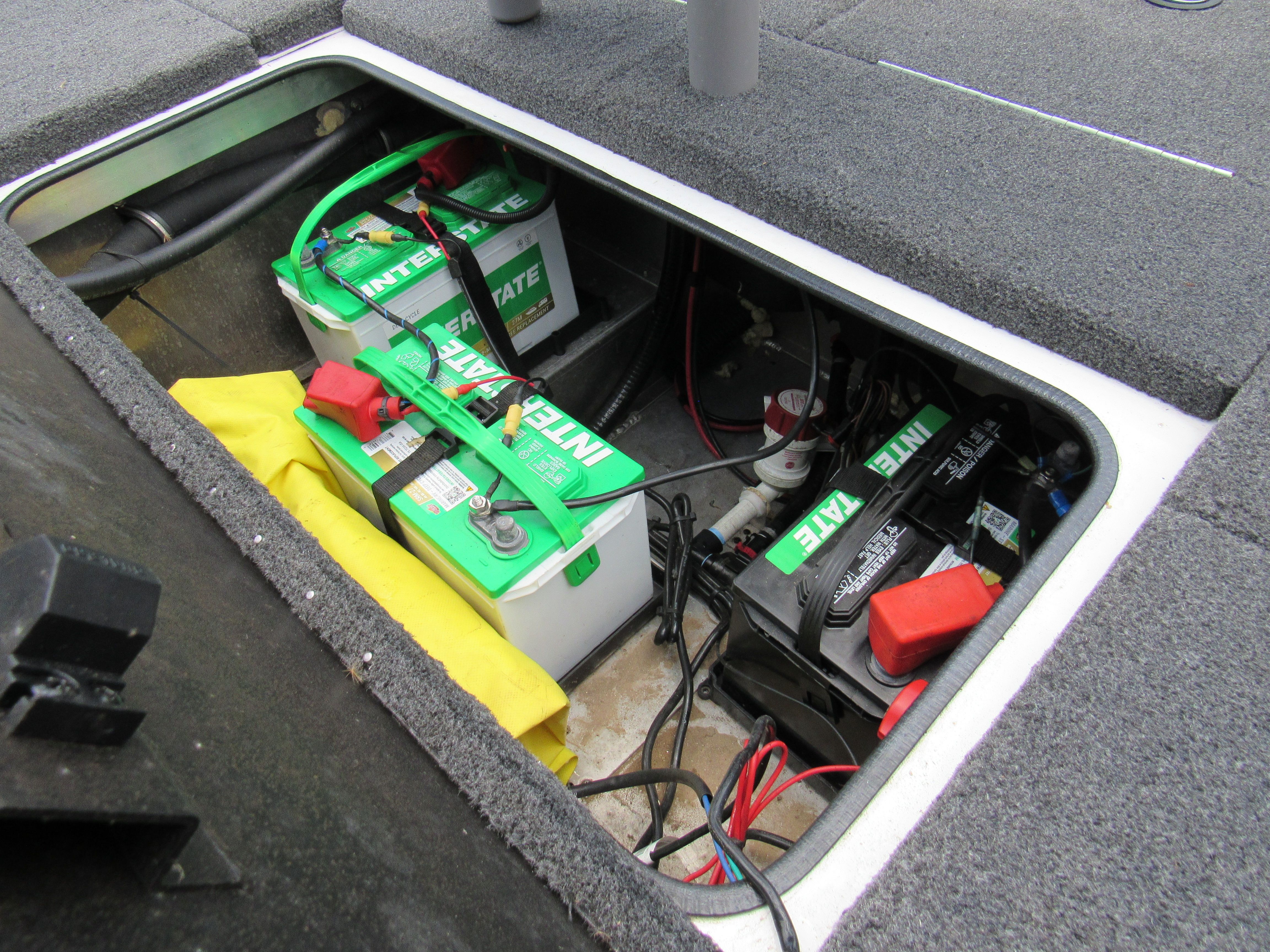 Battery compartment of a Vexus AVX 1880 boat with multiple batteries and cables.