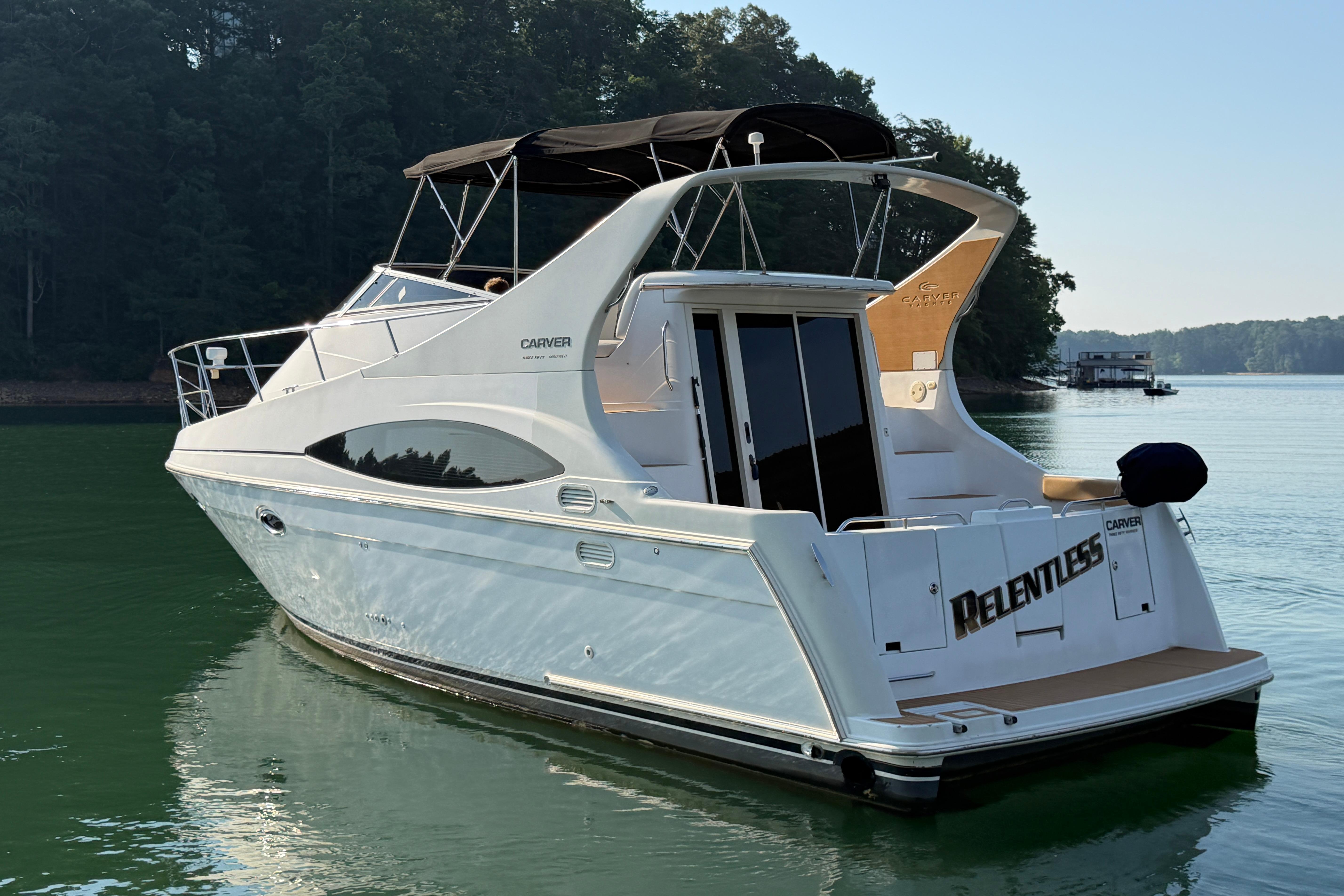 2003 Carver 350 Mariner yacht on serene lake, featuring sleek design and spacious deck.