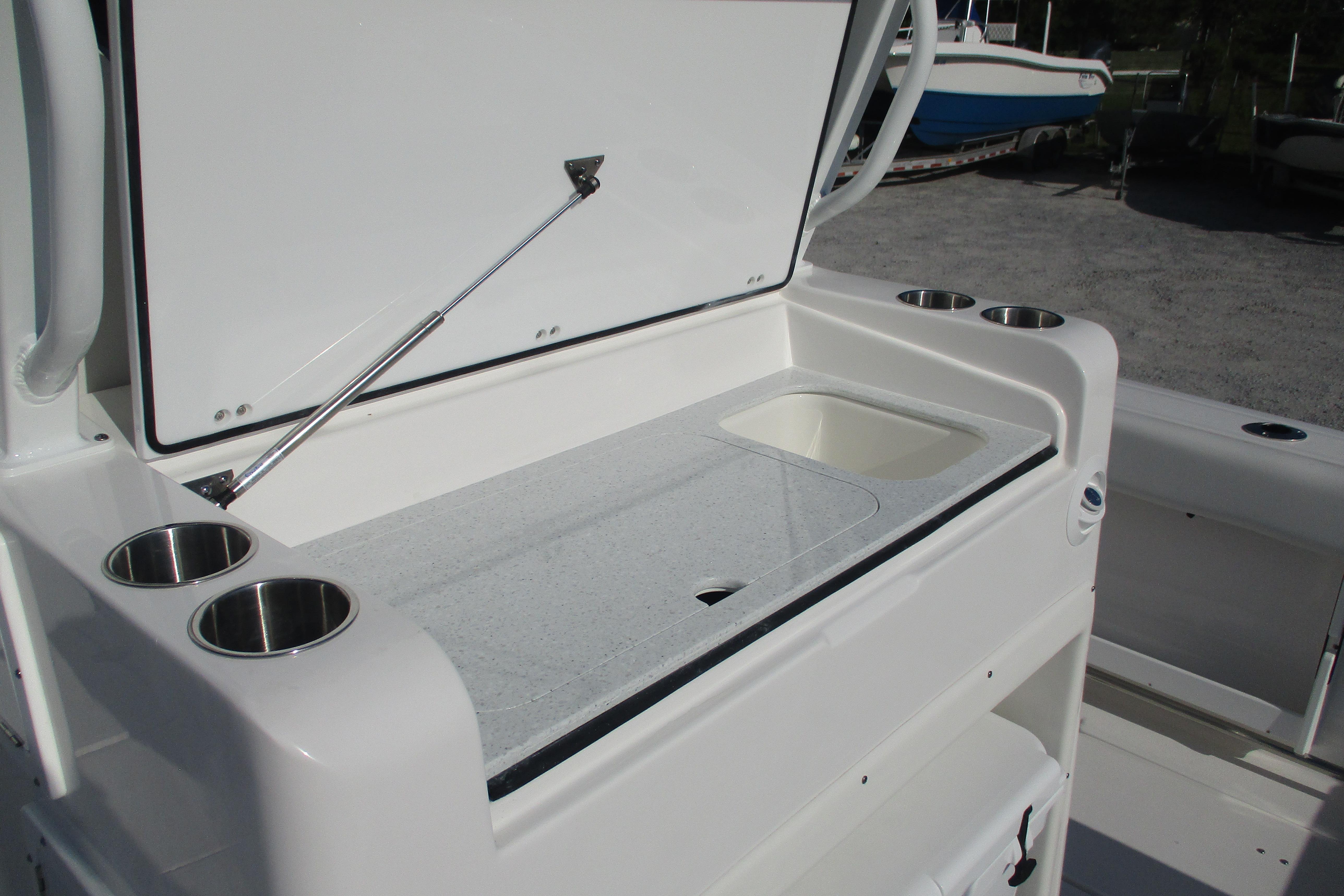 2026 Sea Fox 328 Commander boat with open storage compartment and cup holders.