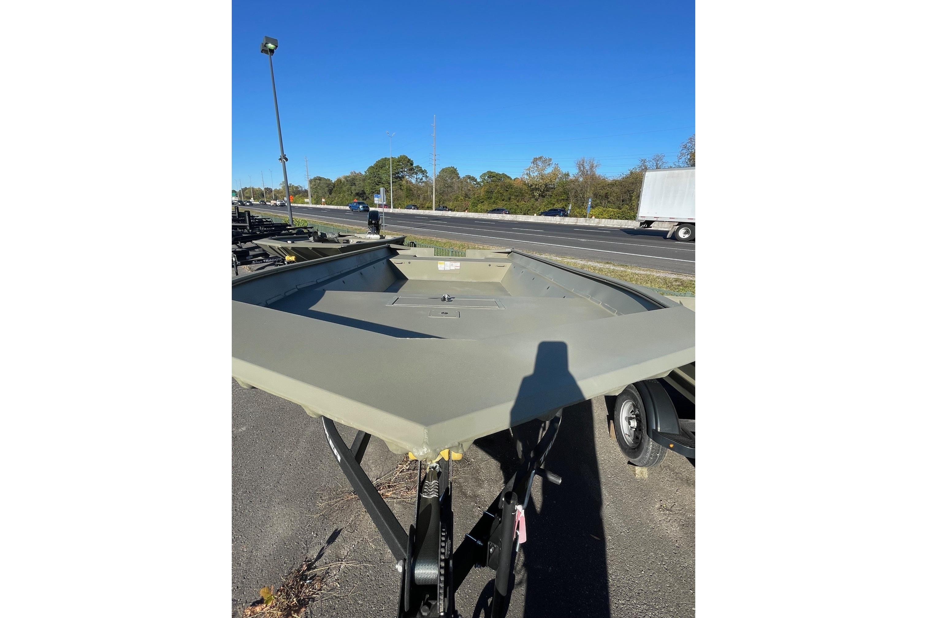 2025 Tracker Grizzly 2072 Utility boat on trailer, parked near highway under clear blue sky.