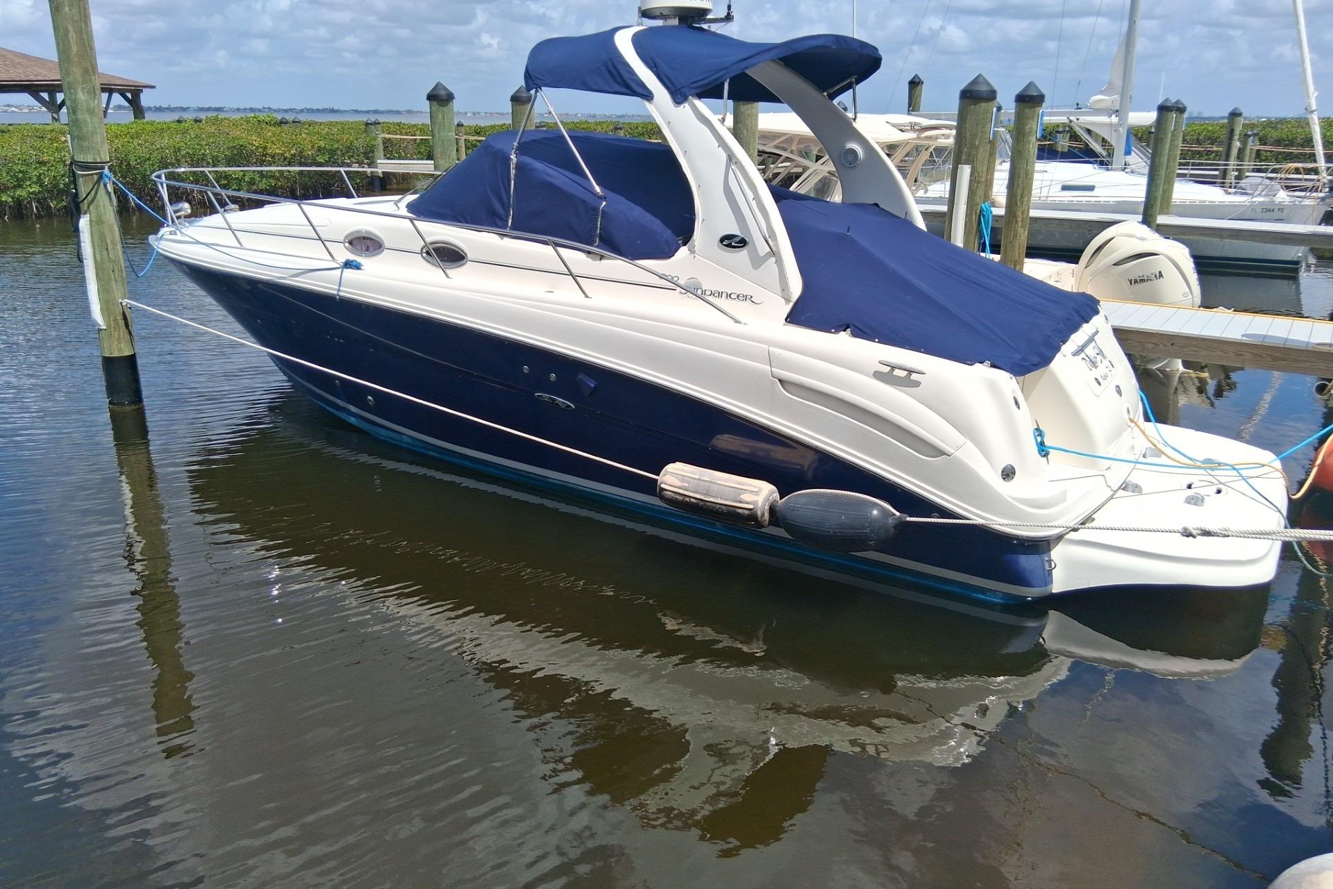 2005 Sea Ray 300 Sundancer boat docked in marina, featuring blue and white design.