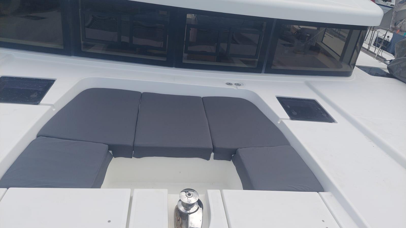 2016 Lagoon 52 yacht with cushioned deck seating and sleek design.