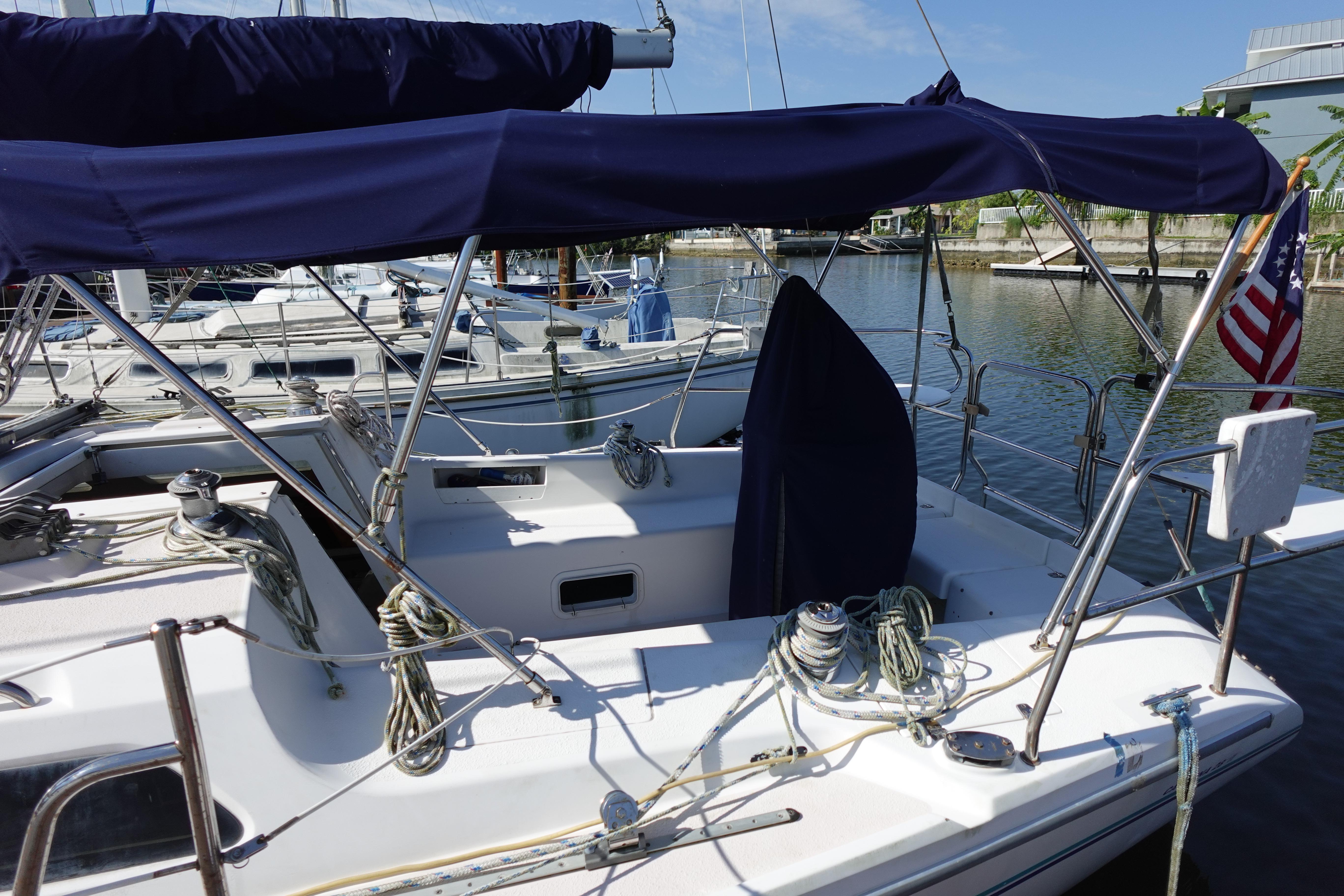 1997 Catalina 28 sailboat docked, featuring blue canopy and American flag.