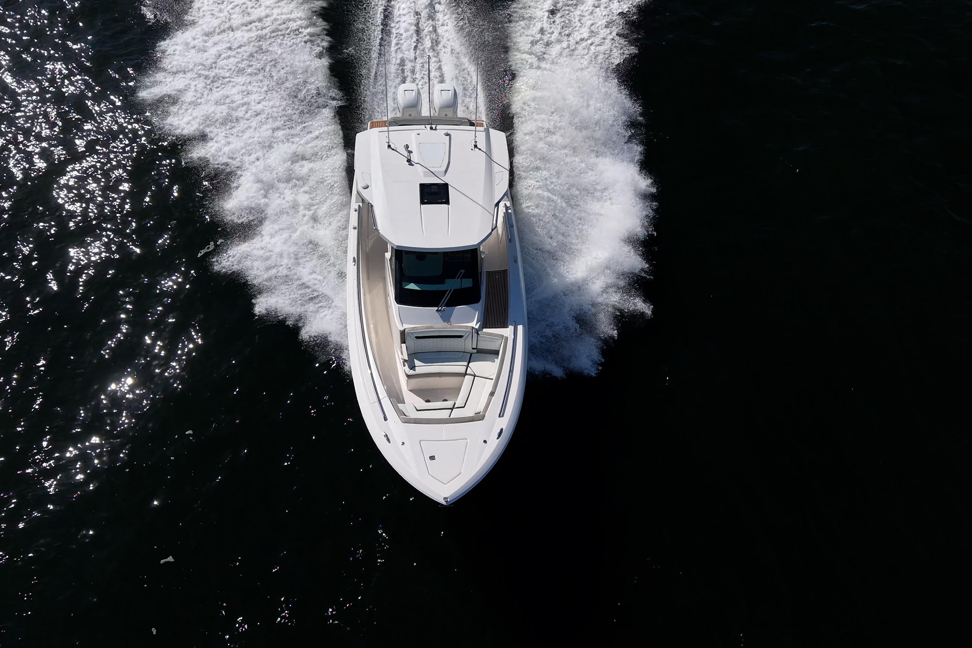 Aerial view of 2023 Tiara Sport 34 LS boat cruising on water.