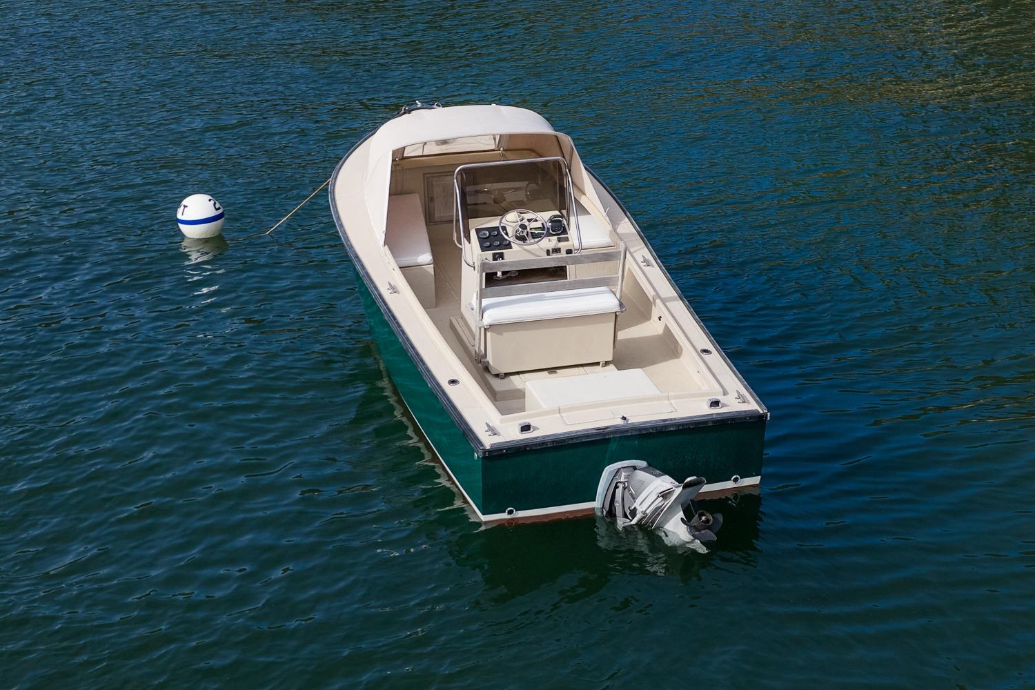 1989 Ellis 24 Open boat on water, featuring a sleek design and outboard motor.