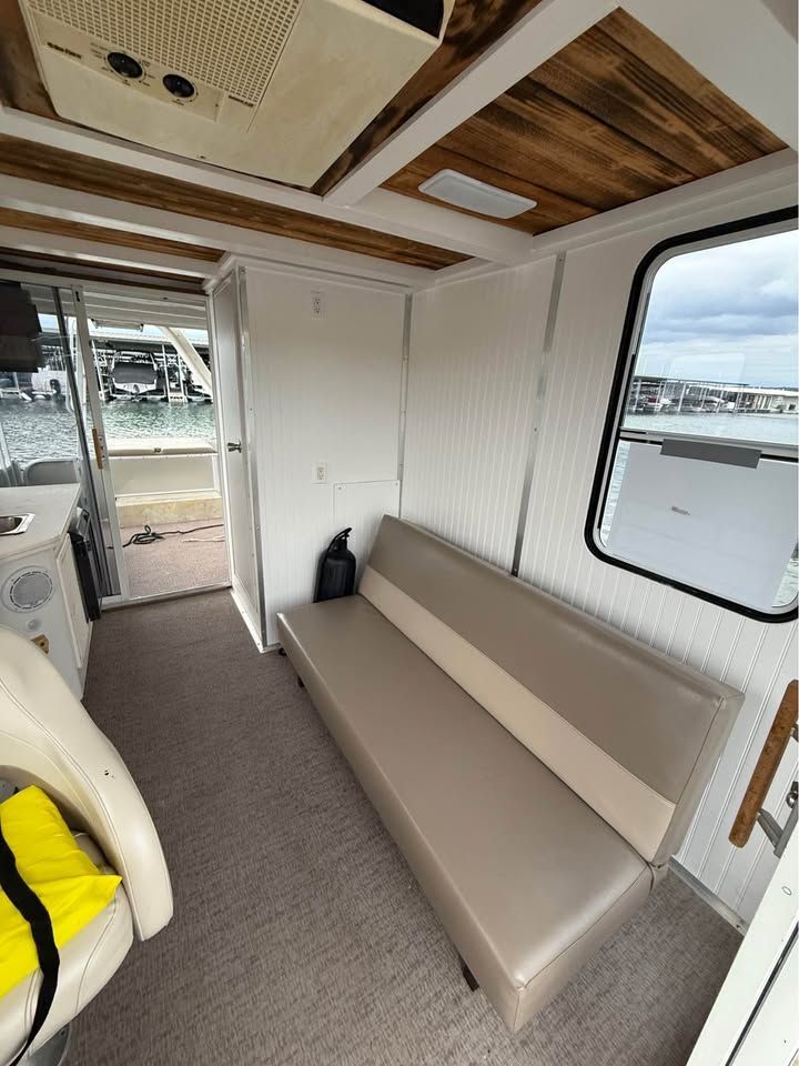 Interior of a 2008 Sun Tracker Party Cruiser with sofa and window.