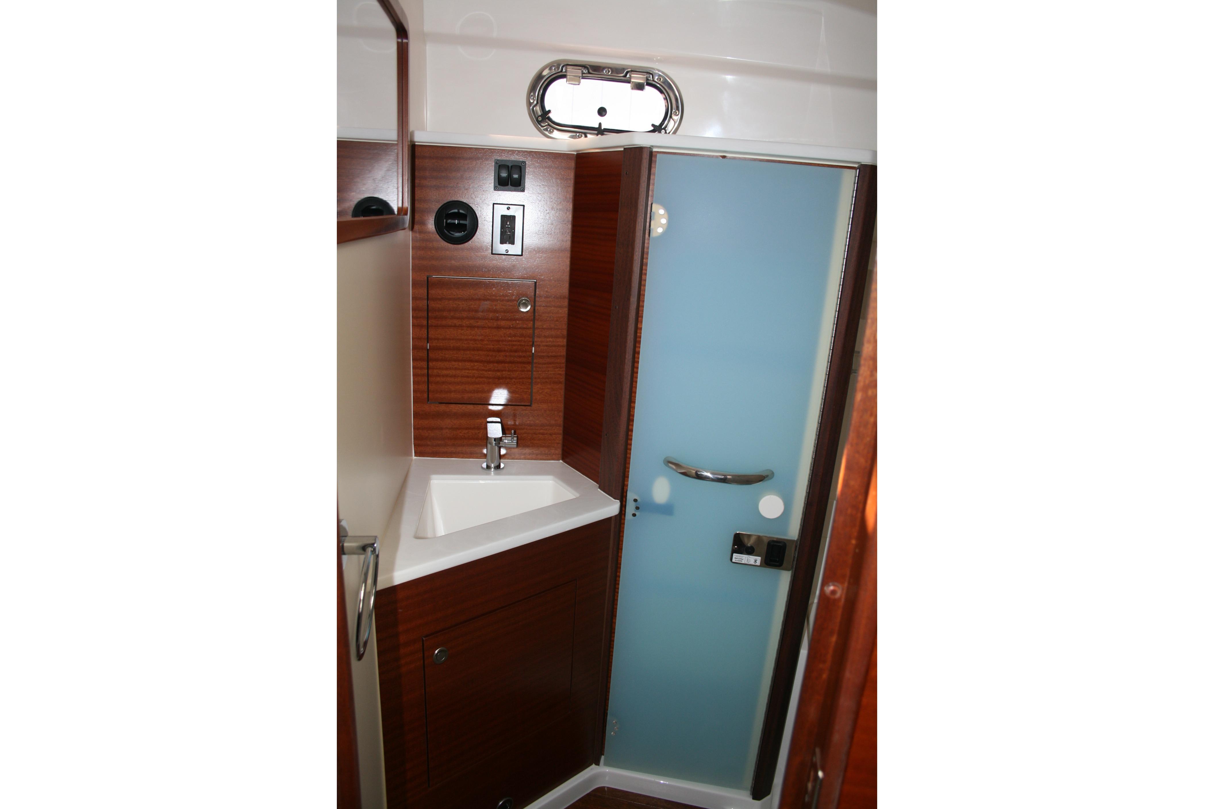 2025 Pursuit OS 405 Offshore yacht bathroom with sink and frosted glass door.