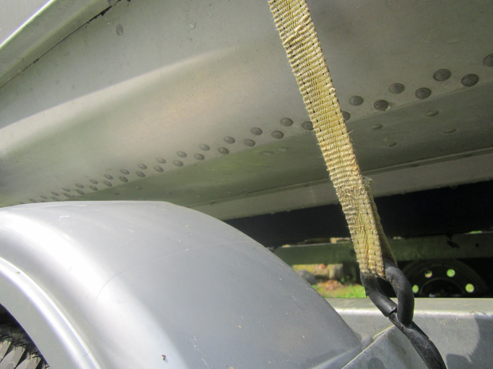 Close-up of a boat trailer with strap and wheel cover.