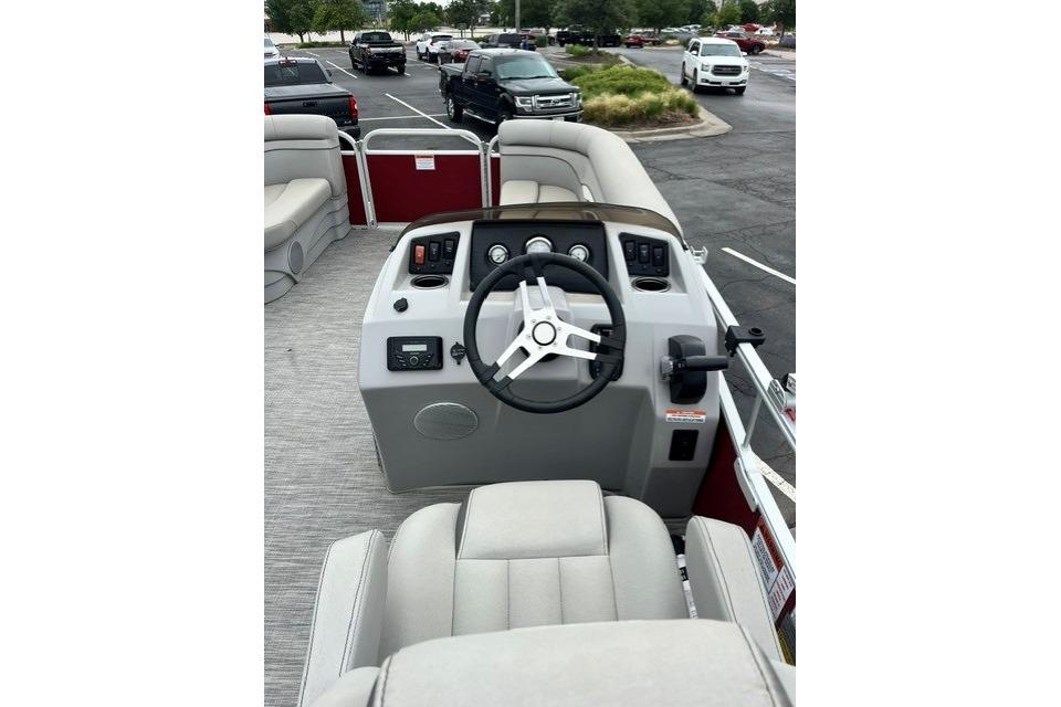 2021 Bennington 205SL boat interior with steering wheel and seating in a parking lot.