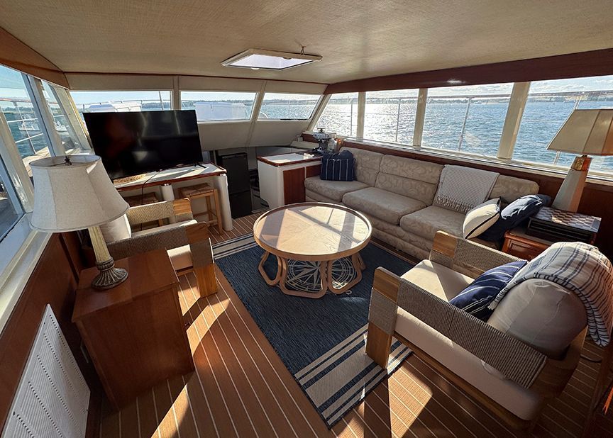 Interior of a 1961 Burger 63 yacht with cozy seating and large windows.