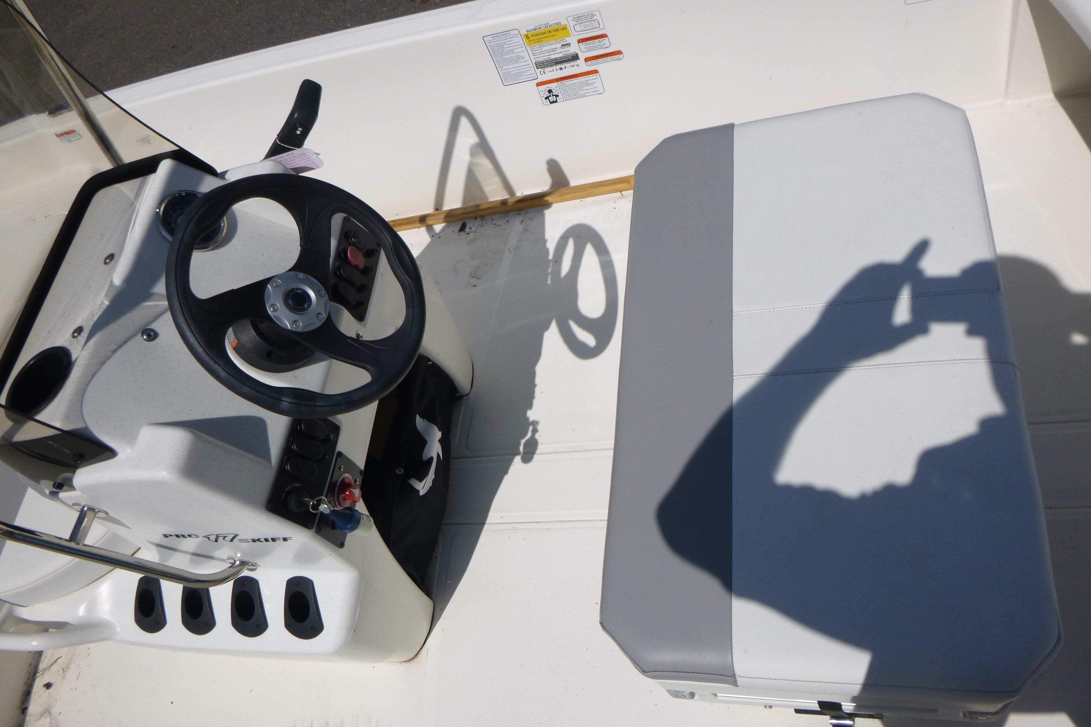 2024 Mako Pro Skiff 17 CC boat interior with steering wheel and seating.
