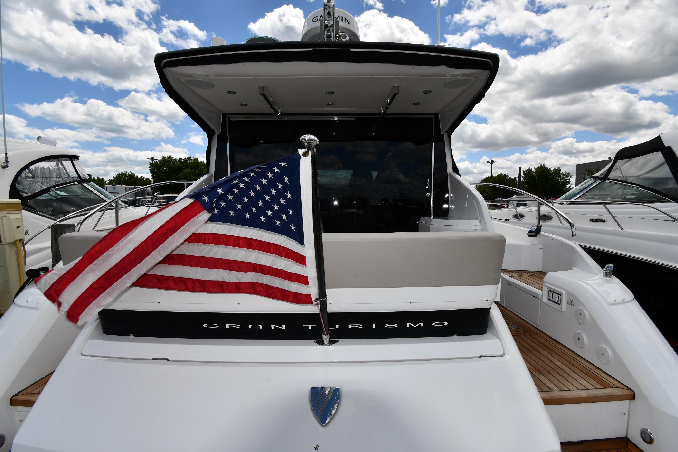 2024 Fairline G50 Targa yacht with American flag, docked under a cloudy sky.