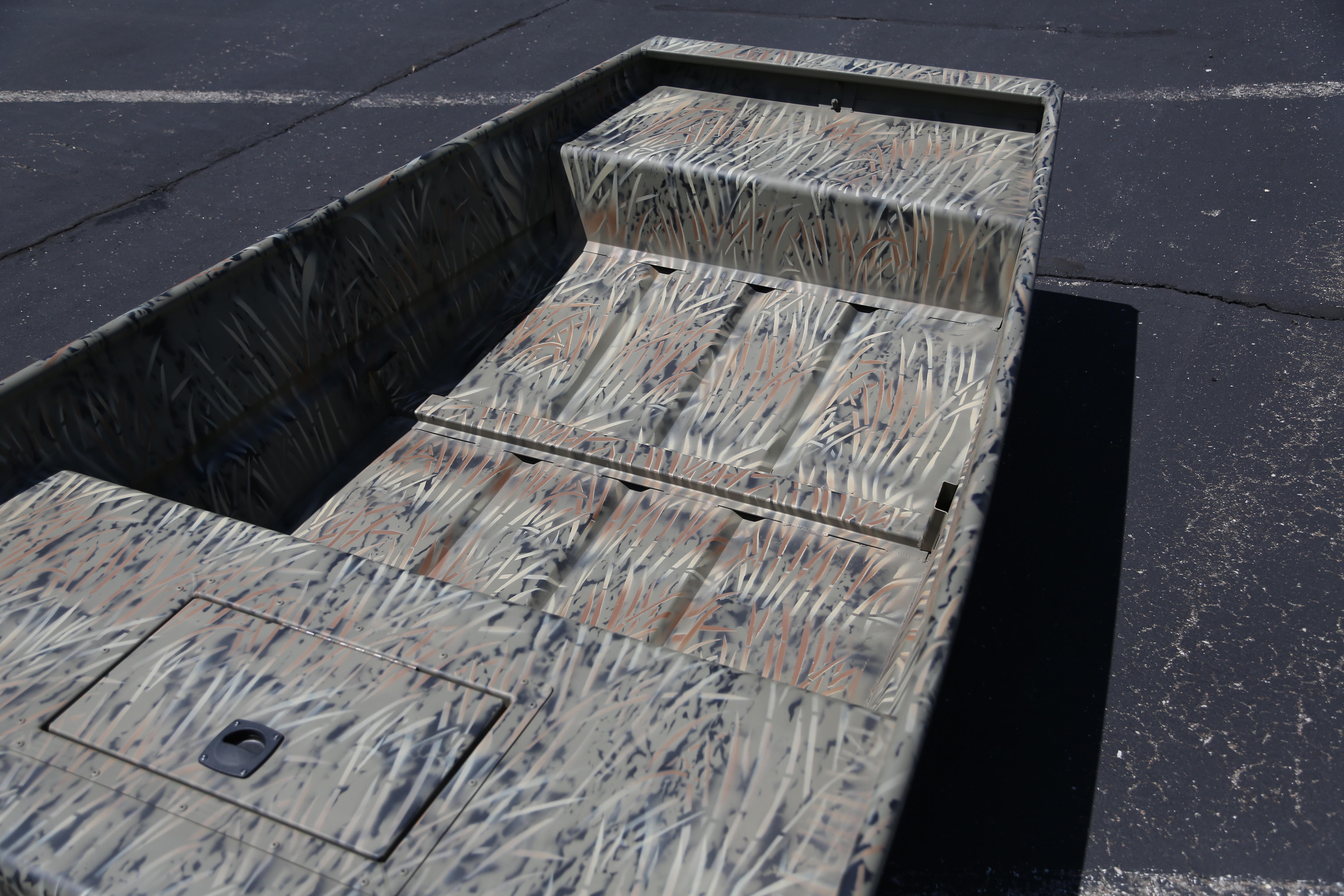 2026 Tracker Grizzly 15 Jon boat with camouflage design on pavement background.