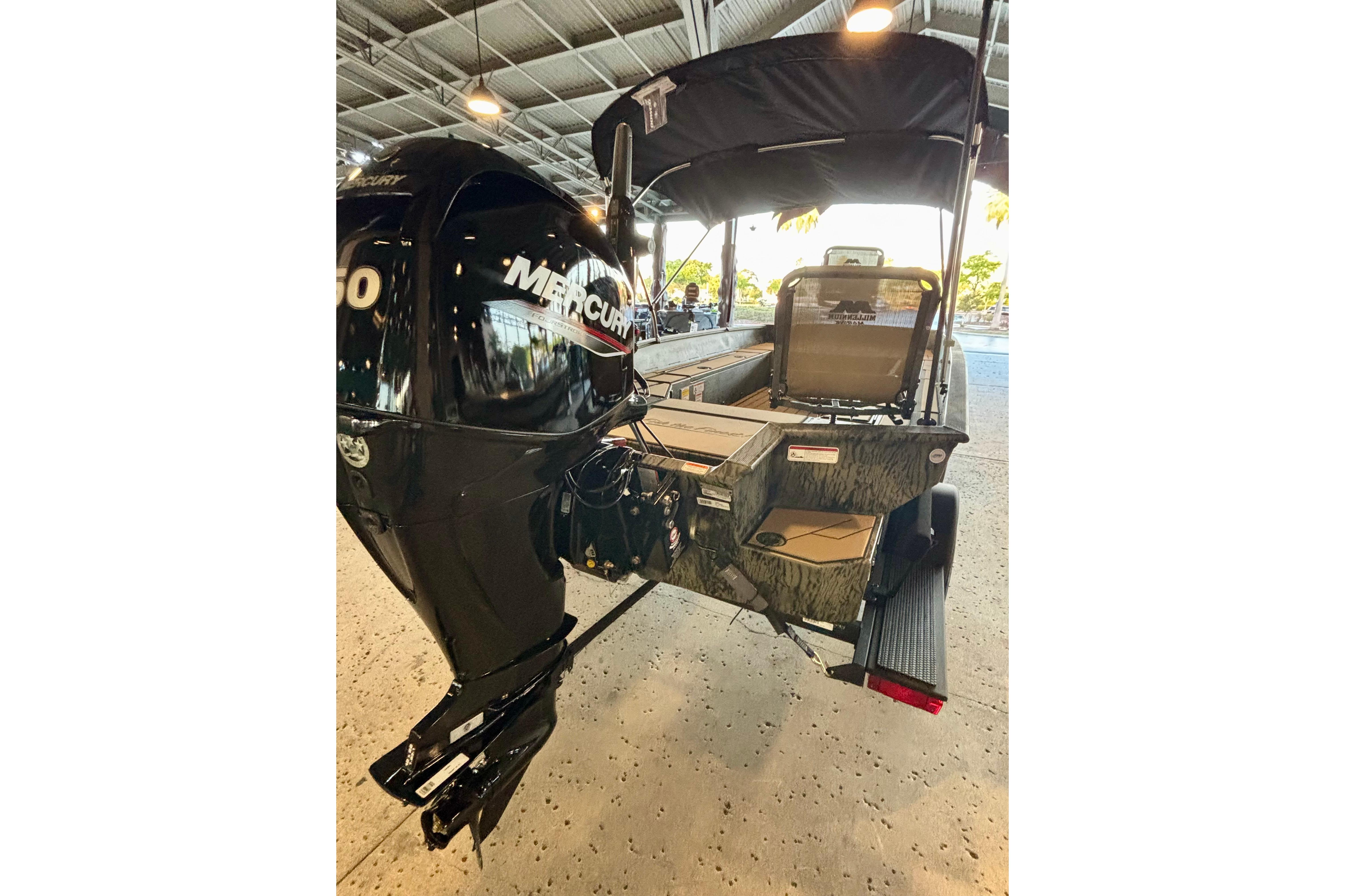 2026 Tracker Grizzly 1756 T Marsh boat with Mercury engine in a showroom.