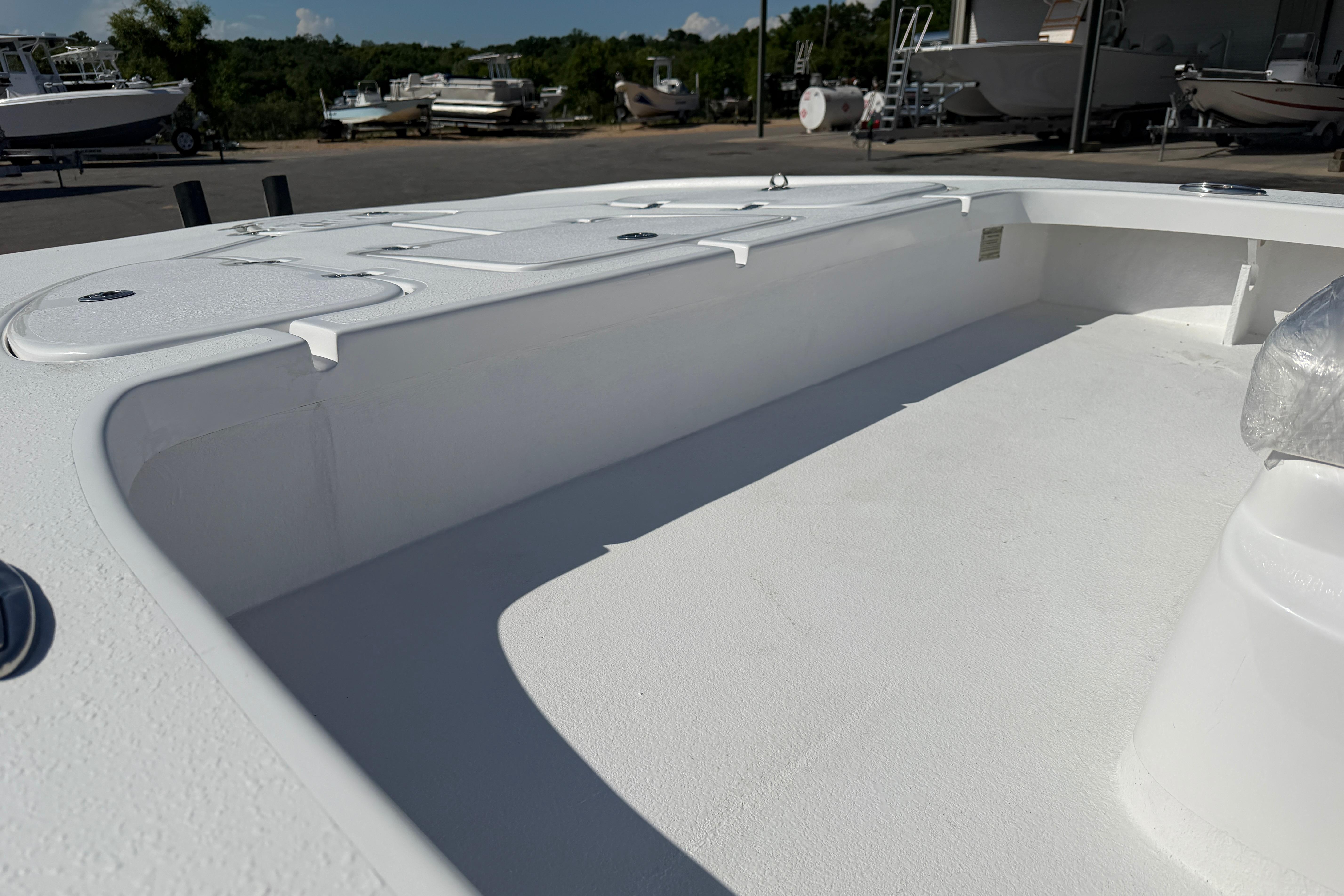 2026 Skuta 24 Cat boat interior with white deck and storage compartments.
