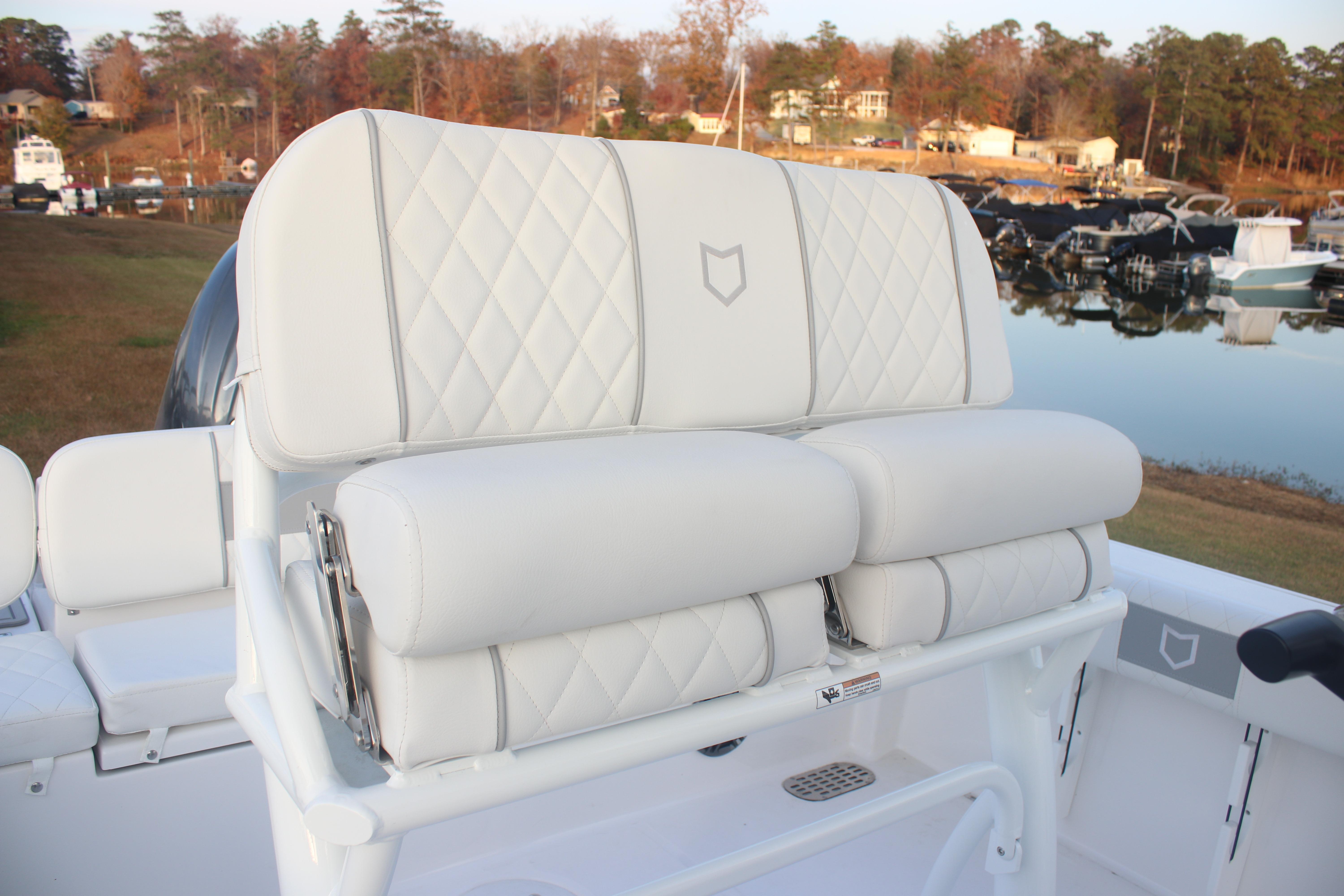 2026 Sea Fox 228 Commander boat with white cushioned seating by a serene lake.