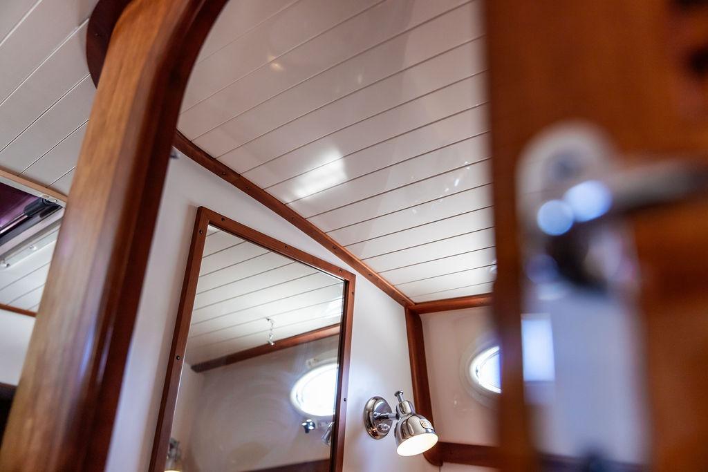 Interior of 2000 Hinckley Picnic Boat 36 Classic with wood paneling and porthole window.