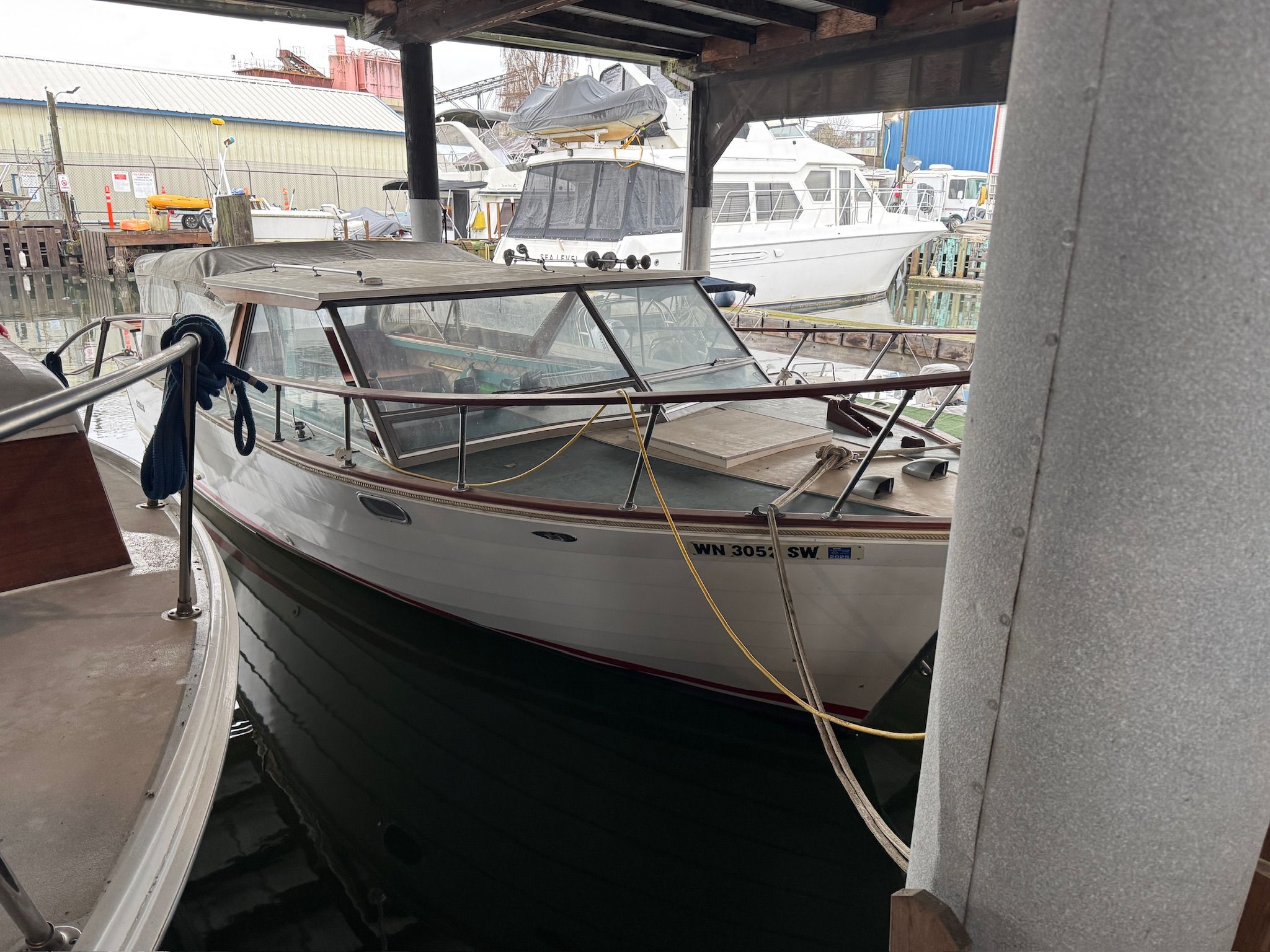 A 1972 Skiff Craft Hardtop is docked in a covered marina area. Other boats are visible in the background.