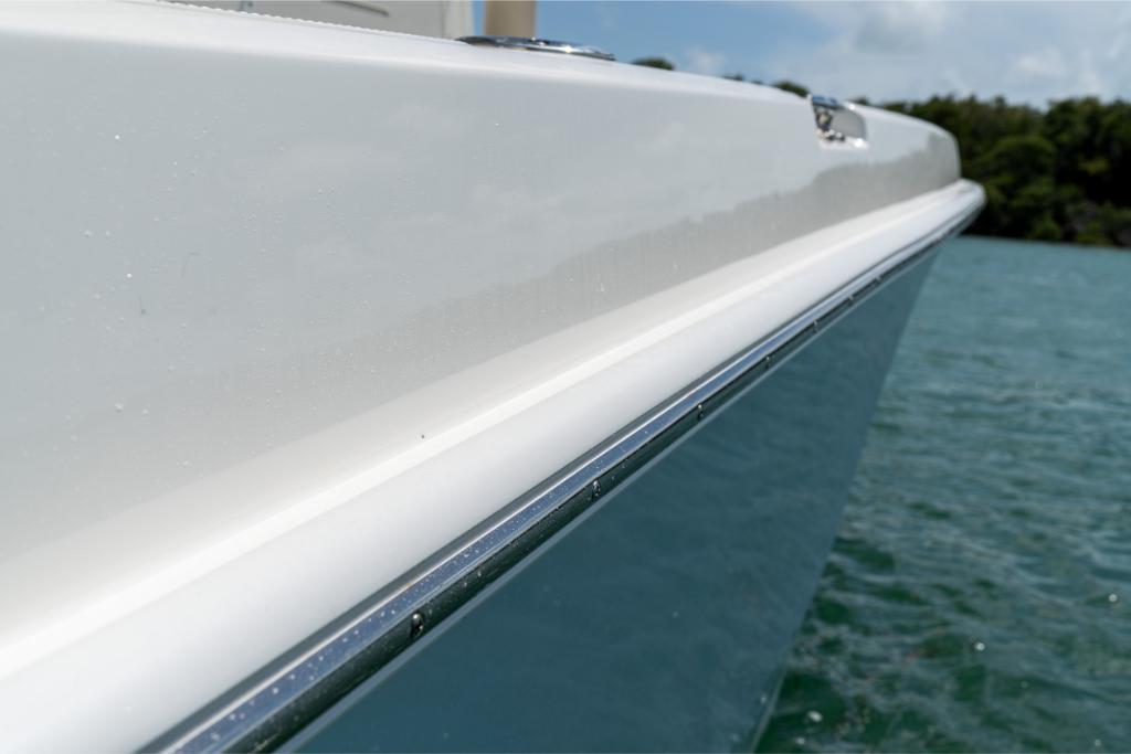 Close-up of the 2024 Boston Whaler 280 Dauntless boat hull on water.