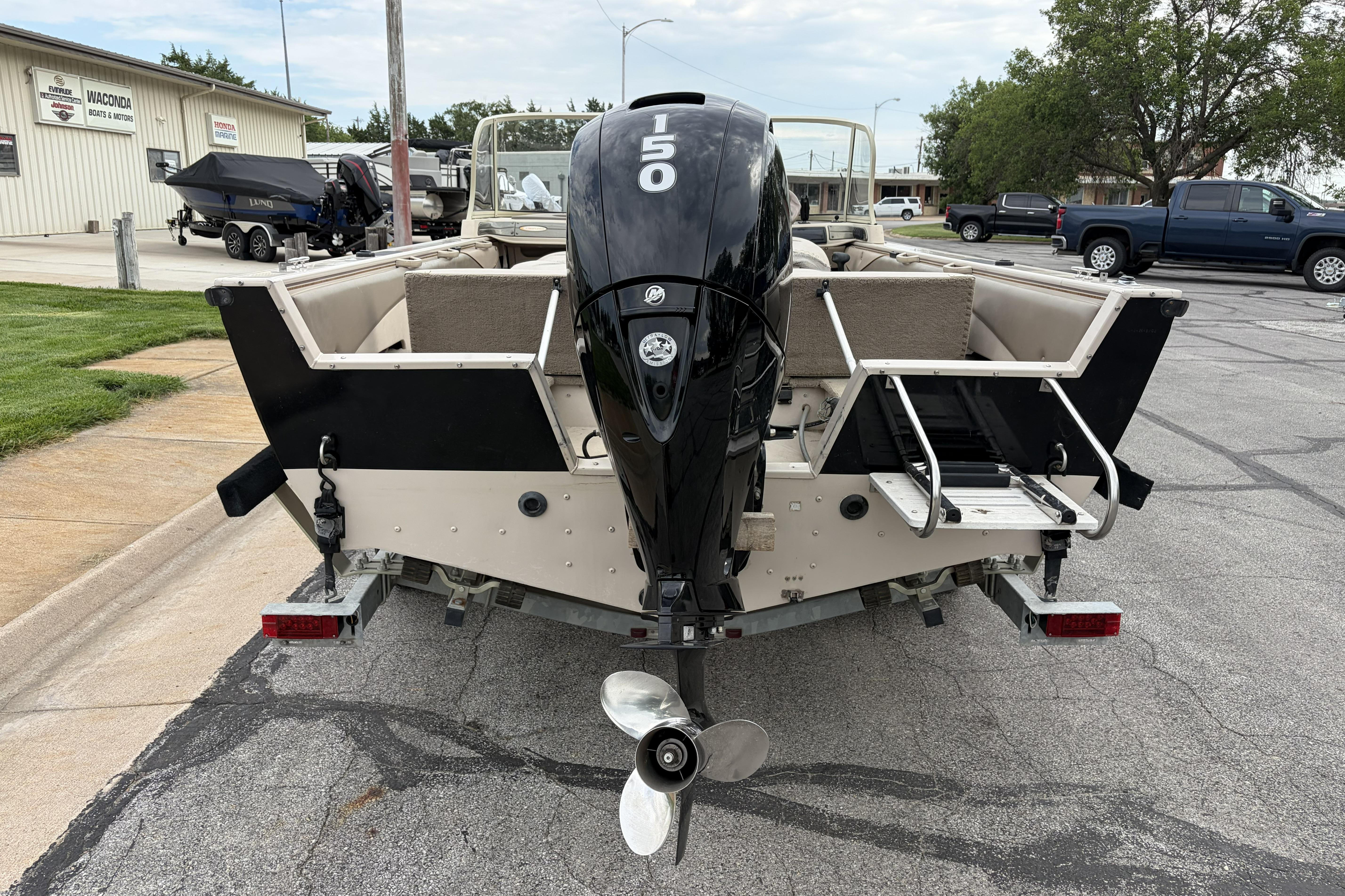 2002 Crestliner 1850 Sportfish boat with powerful outboard motor, parked on a trailer.