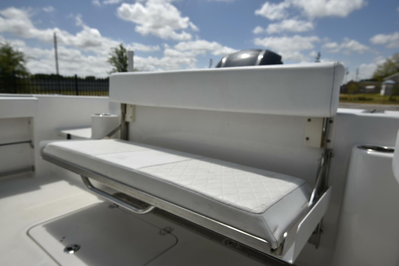 2023 Sea Pro 239 Deep V CC boat with white cushioned seating under a blue sky.