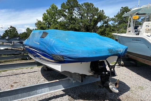 Covered 2012 Tahoe Q8 SSi boat on trailer, parked outdoors near other boats.